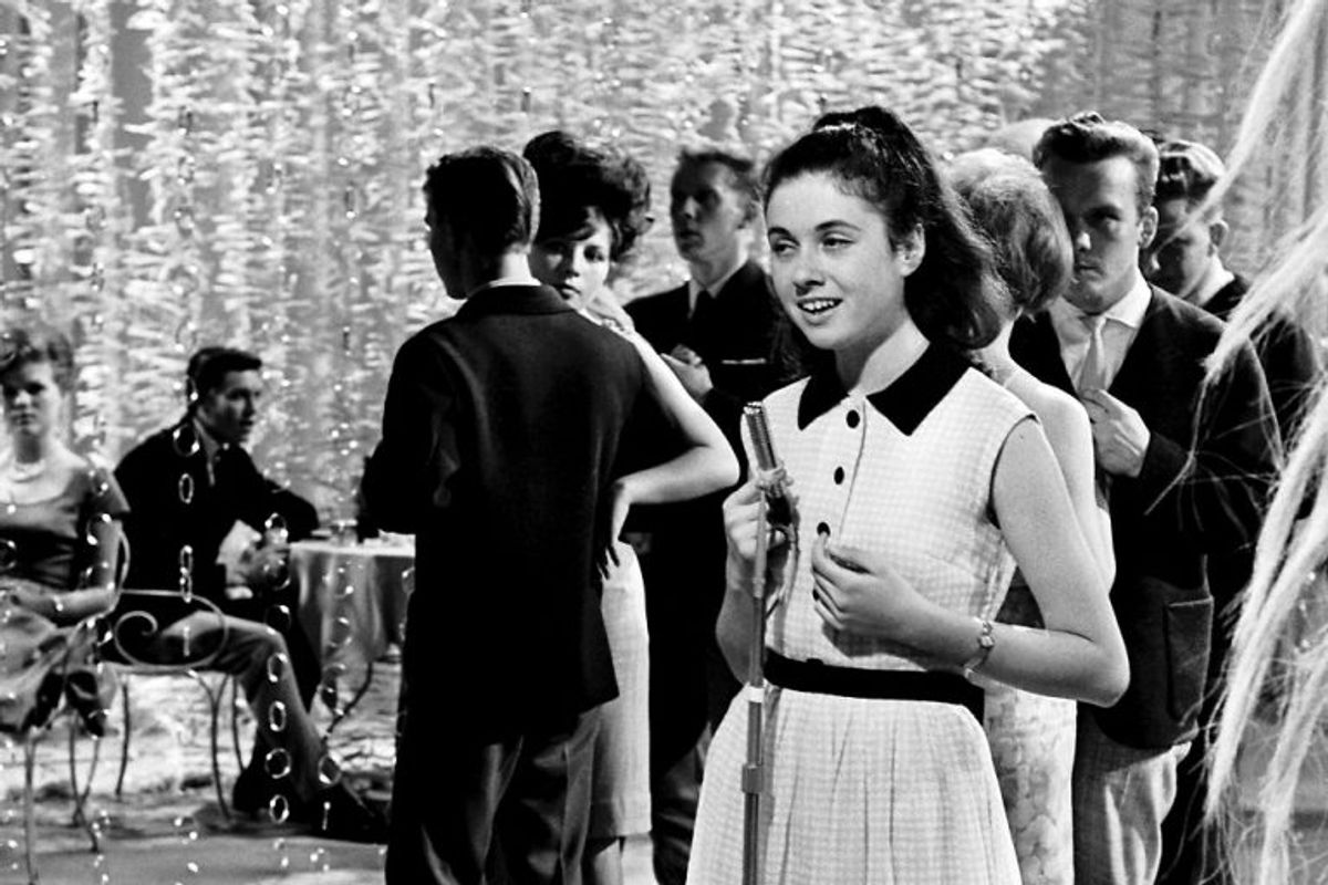 1964: Årets Melodi Grand Prix blev holdt i København, hvor den kun 16-årige italienske pige Gigliola Cinquetti blev en sikker vinder med sangen Non ho l”eta. Her er hun sammen med danske teenagere i en tv-udsendelse efter sejren. Foto: Mogens Ladegaard/Scanpix (Arkivfoto)