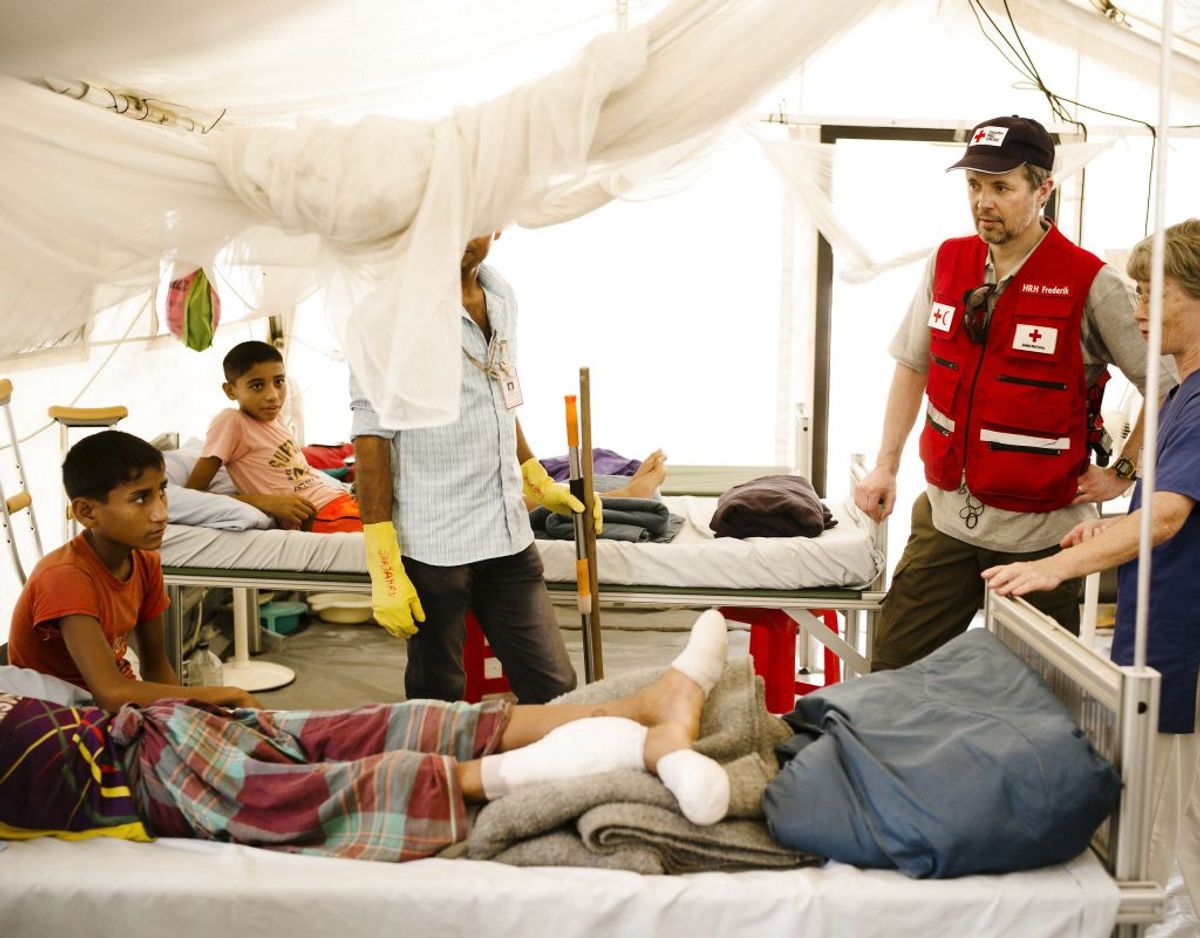 Kronprins Frederik taler med to drenge, som er indlagt på Røde Kors felthospital med brækkede ben, i verdens største flygtningelejr ved Cox”s Bazar i Bangladesh, onsdag den 4. april 2018. Skaderne er opstået ved fald på de stejle skråninger i lejren. Med monsunregnens komme frygter Røde Kors’ læger og sygeplejersker, at mange flere vil komme til skade. Foto: Jakob Dall/Scanpix.