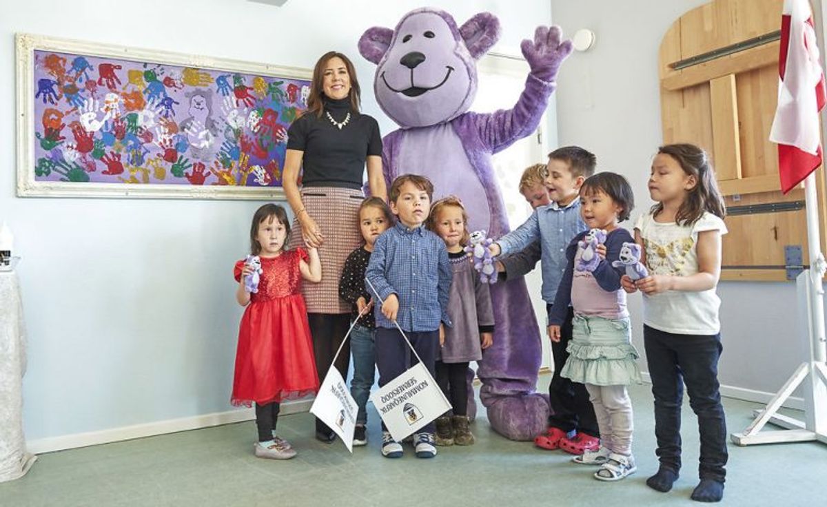Børnehaven Sikkersoq i Nuuk arbejder med Mary Fondens projekt Kammagiitta (fri for mobberi). Kronprinsessen sammen med nogle af børnene der lige som Kronprinsessen har sat deres håndaftryk på billedet bag dem. Foto: Ulrik Bang/Scanpix.