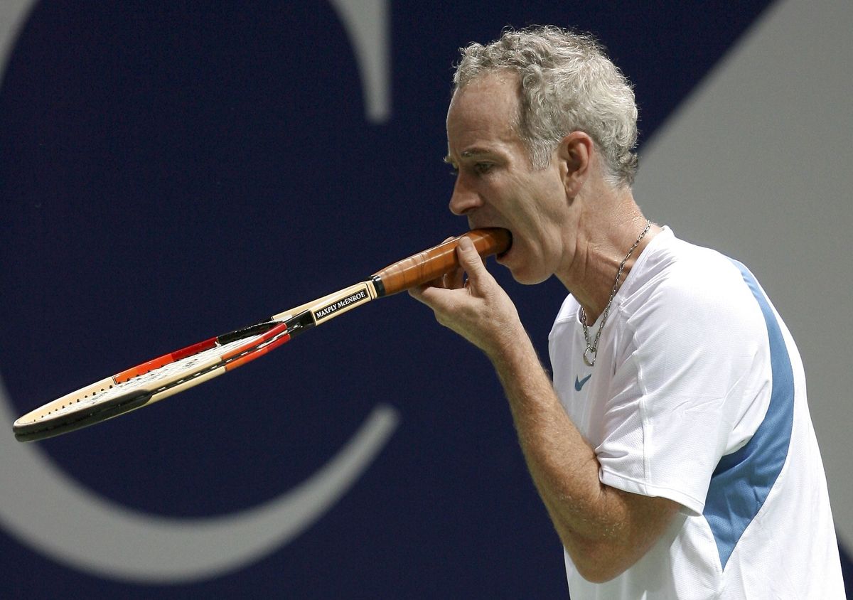 John McEnroe tager ketcheren i munden efter han missede en bold mod Björn Borg under 'The Legends Rock Dubai' i 2006.
