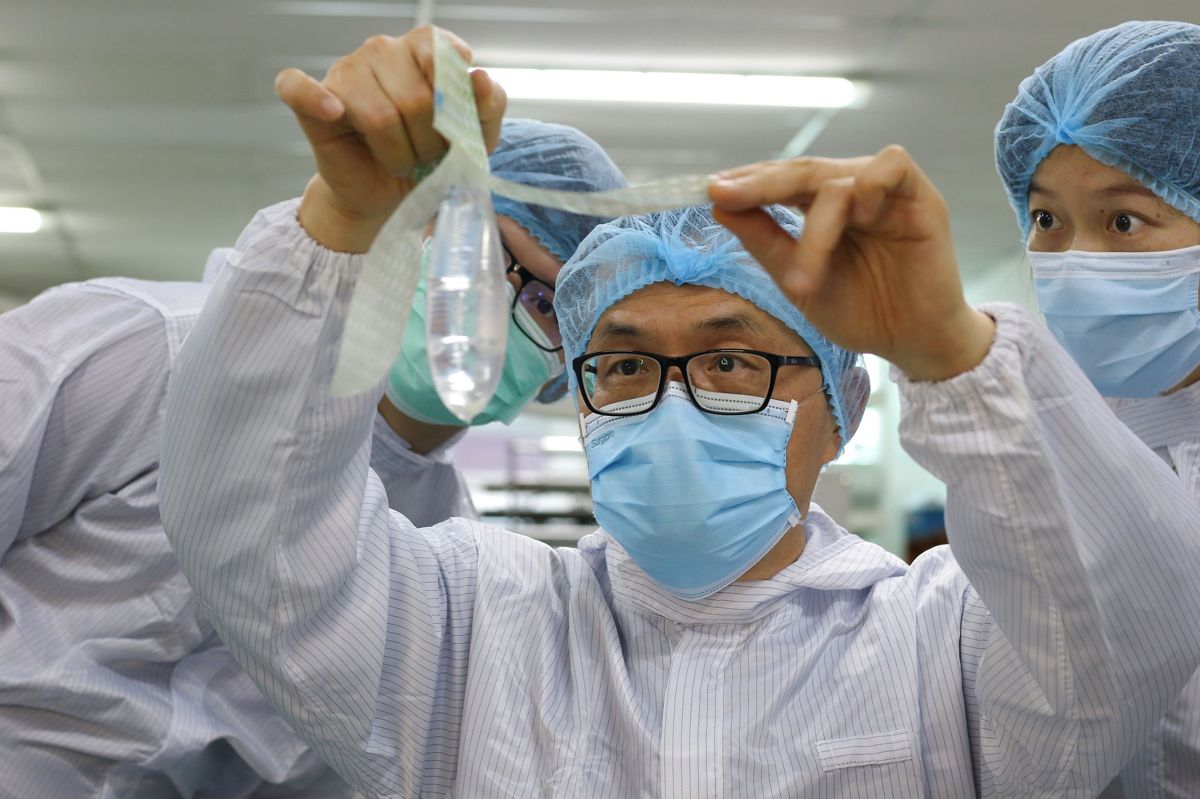 Gynækolog og stifter af Wondaleaf Unisex Condom, John Tang Ing Chinh, inspicerer et af sine særligt udviklede kondomer på en fabrik i Malaysia.
