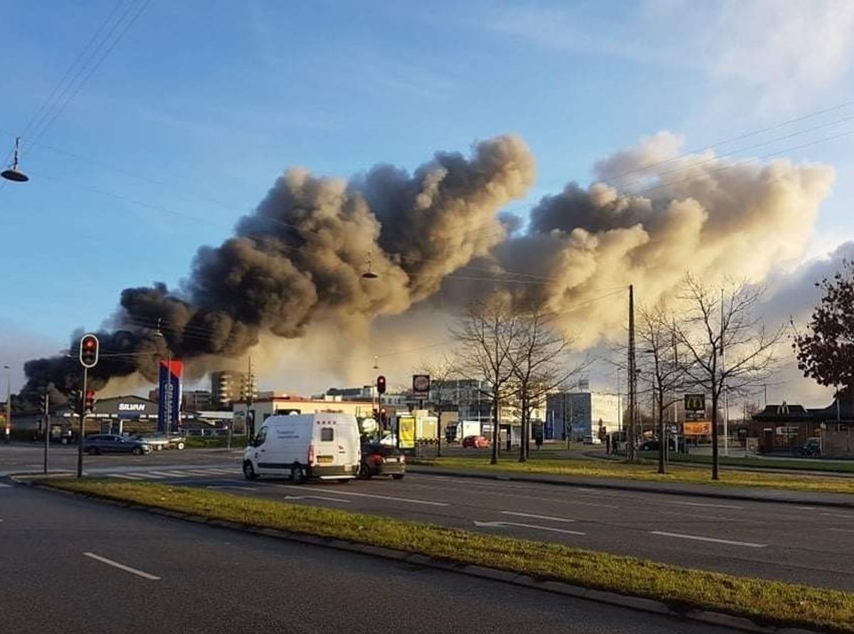 Flammerne har godt fat i forretningen. Det ryger voldsomt fra branden.