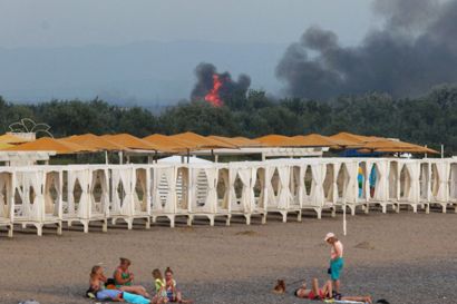 En russisk militærbase på Krim-halvøen blev tirsdag ramt af eksplosioner, mens strandgæster solede sig ikke så langt fra basen.