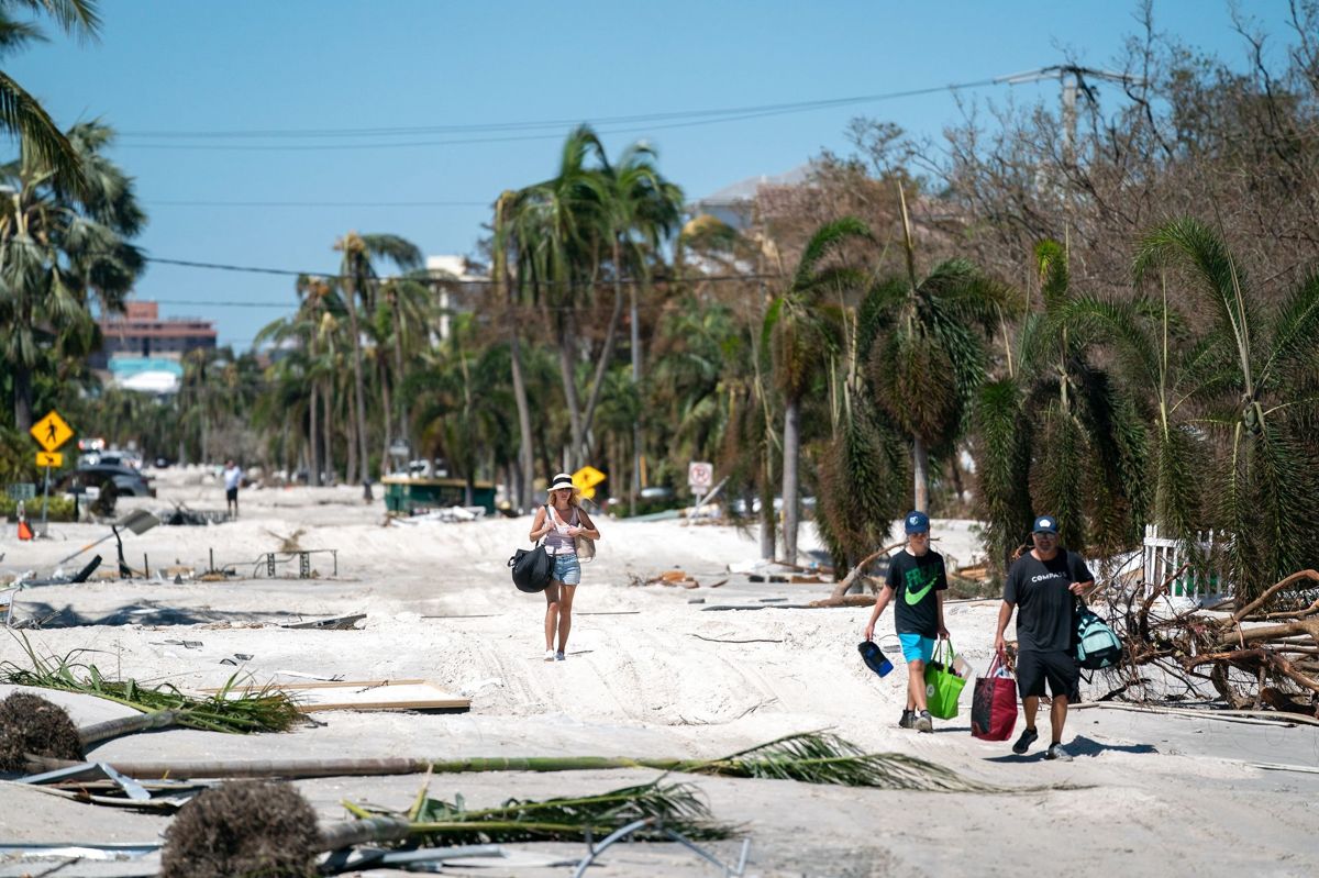 Flere husejere i Bonita Springs i Florida bærer deres ejendele ud af deres huse, efter at orkanen Ian har hærget deres nabolag.