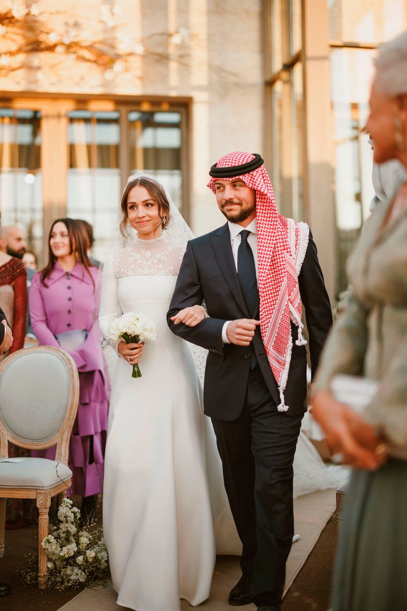 Prinsesse Iman føres ind til ceremonien af sin ældre bror, kronprins Hussein.