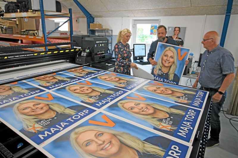 Her er maskinen netop sat i gang. Første opgave var at trykke valgplakater til Maja Torp, der her ses sammen med trykkeriets indehavere, Christian og Frits Danielsen. Foto: Jørgen Ingvardsen