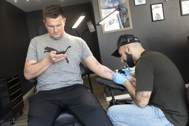 Sallam Ahmadi er ved at tatovere kunden Martin. Det er underarmen, der i dag skal have blæk. Foto: Claus Søndberg