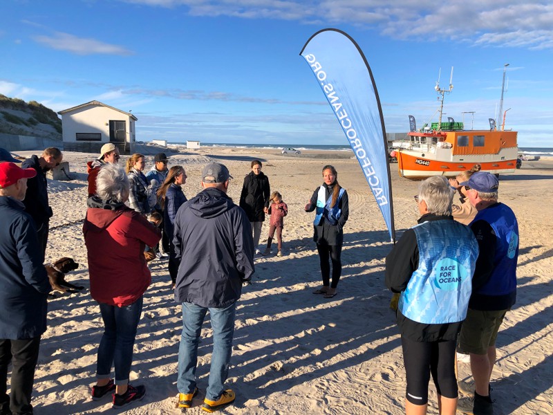 Signe Simonsen i midten byder velkommen til affaldsindsamlingen på stranden i Løkken.