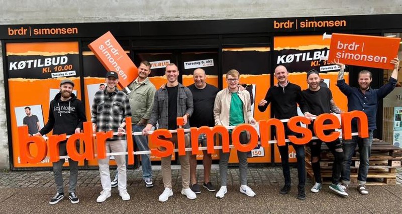 Helt til venstre i billedet er den kommende butikschef, Markus Elkjær. Han er flankeret af blandt andet butikschefer fra andre Brdr. Simonsen-butikker. I midten er det én af de to stiftere af Brdr. Simonsen, Christian Simonsen.