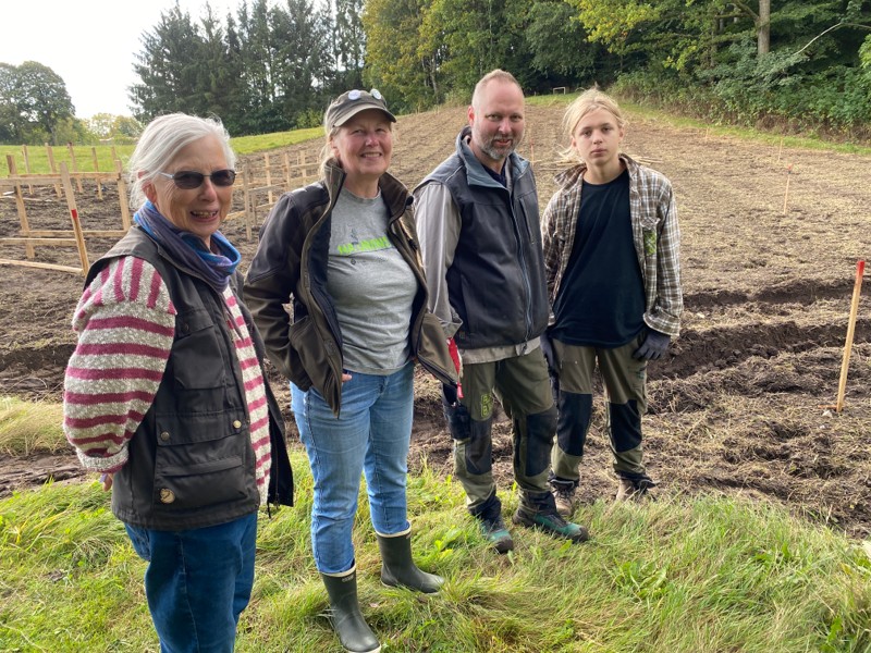 Jorden i baggrunden skal blive til Danmarks - måske - største insekthotel. Det ser Esther Kjeldgaard (v.), formanden for Morsø Naturklub, Inge Jakobsen, Ejer af Biobyg, Mikael K. Bjerre samt hans 13-årige søn, Carlos Bjerre, frem til.