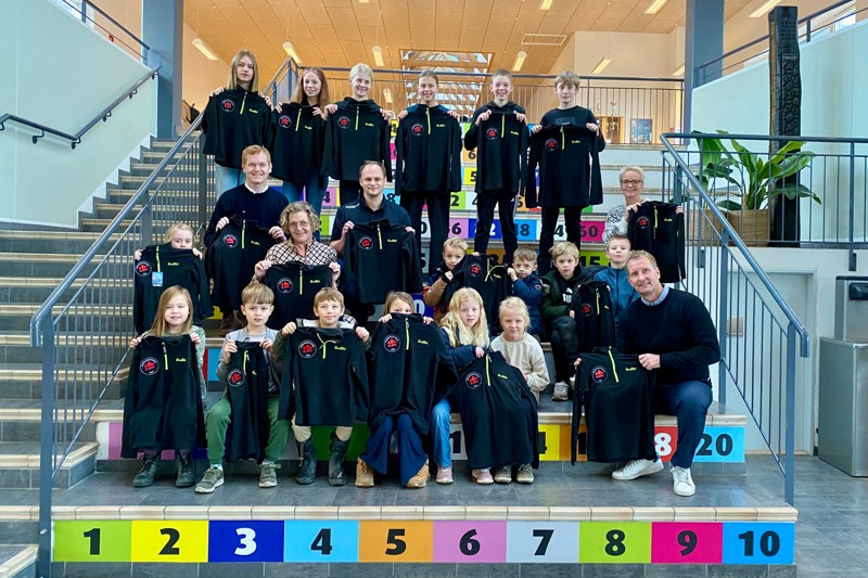 De nye fleecetrøjer skabte glæde hos eleverne fra 1.B, 6.A og 6.B. Med på billedet er Jonas Foged Holm, Feriepartner Thy (tv.), Johnny Andersen, Sportigan Thisted og Hurup og lærerne Malene Larsen og Lotte Vils. Forrest til højre ses skoleleder Per Olesen.