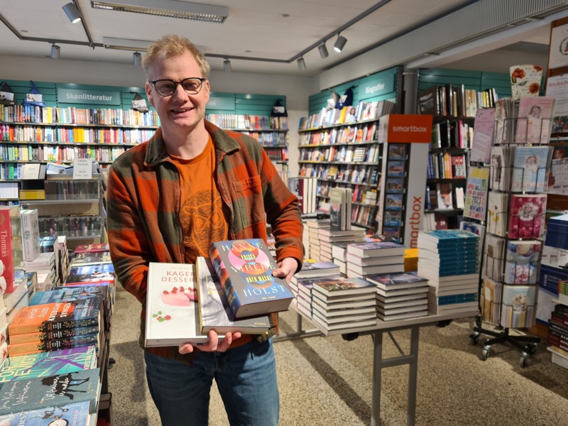 Boghandler Bent Bisgaard fremviser nogle af de bogtitler, der formentlig kommer til at ligge under en del danske juletræer i år.