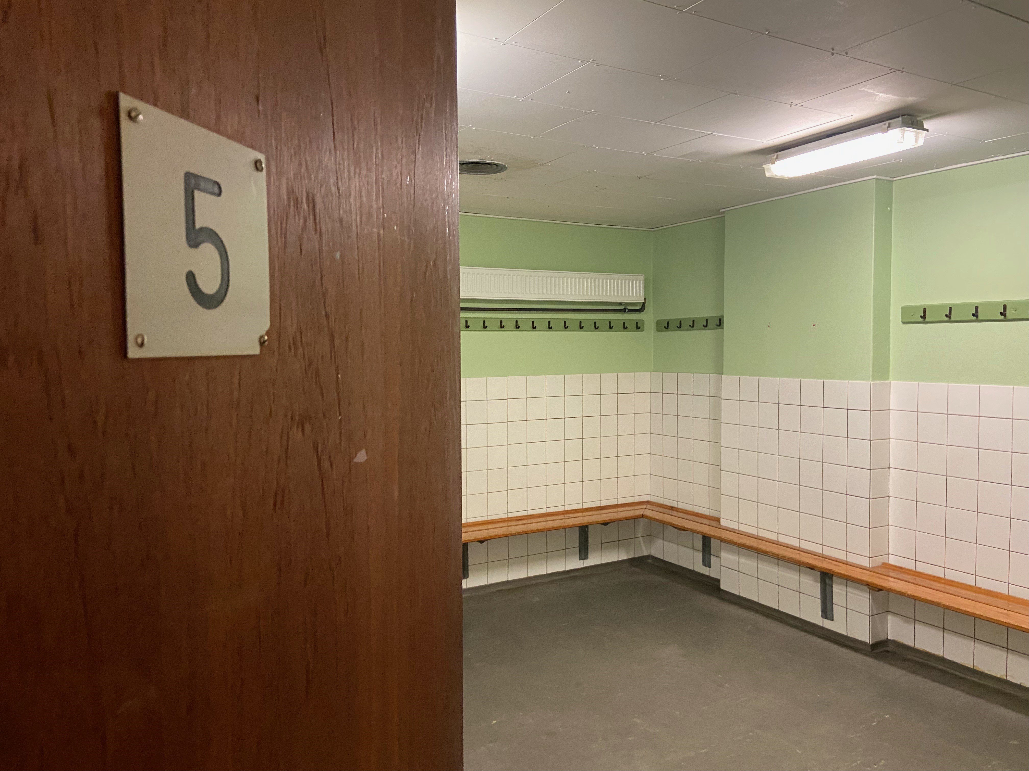 Farvel til Helsingør Hallen, siger Nordsjælland Håndbold, og det skyldes først og fremmest, at den ikke er tidssvarende længere. For eksempel er omklædningsrummene ikke ligefrem luksuriøse. Bemærk den meget smalle bænk.