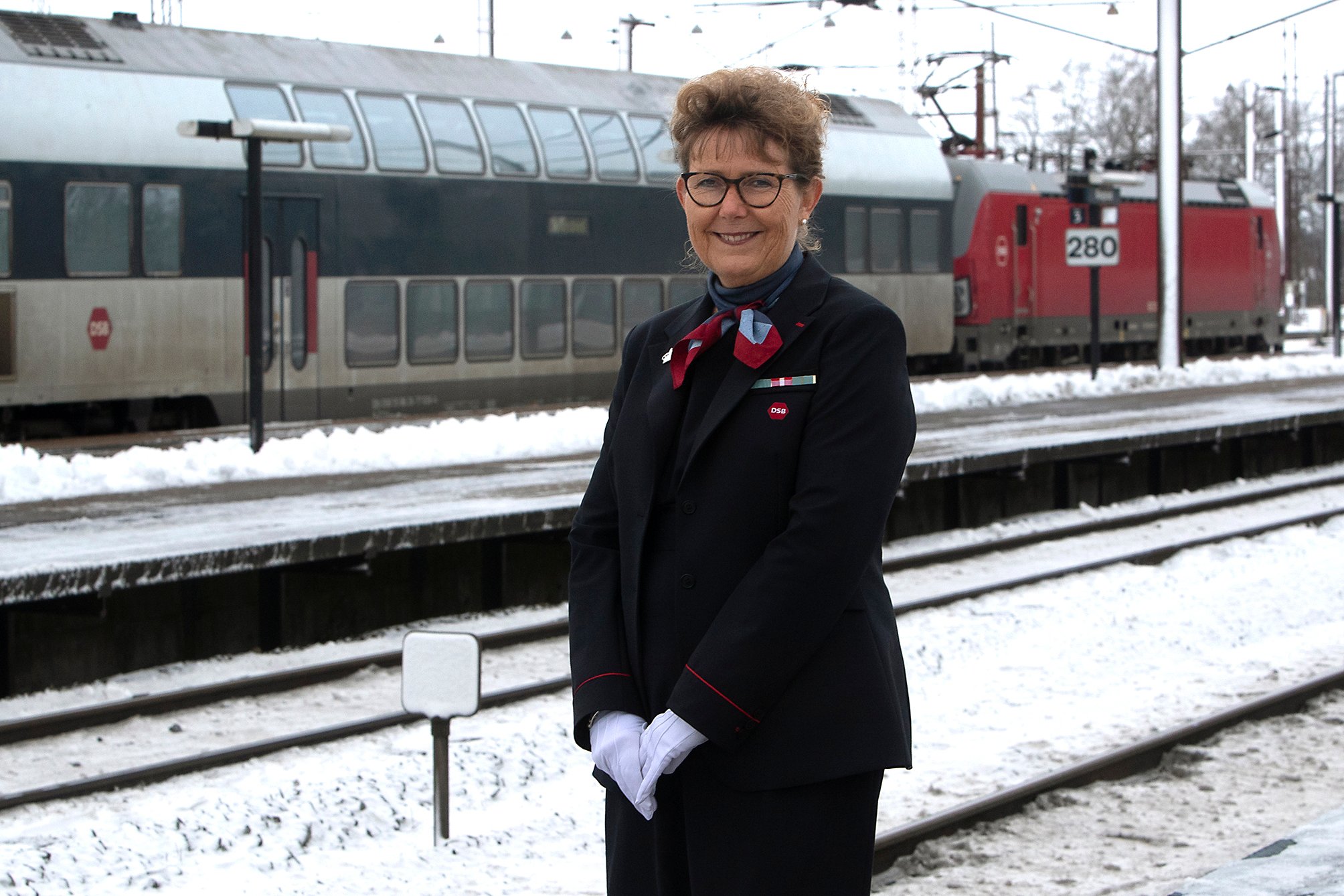 Den vanlige uniform bliver prydet med en kongelig broche og hvide handsker, når Karin Lund er togfører for dronningen.