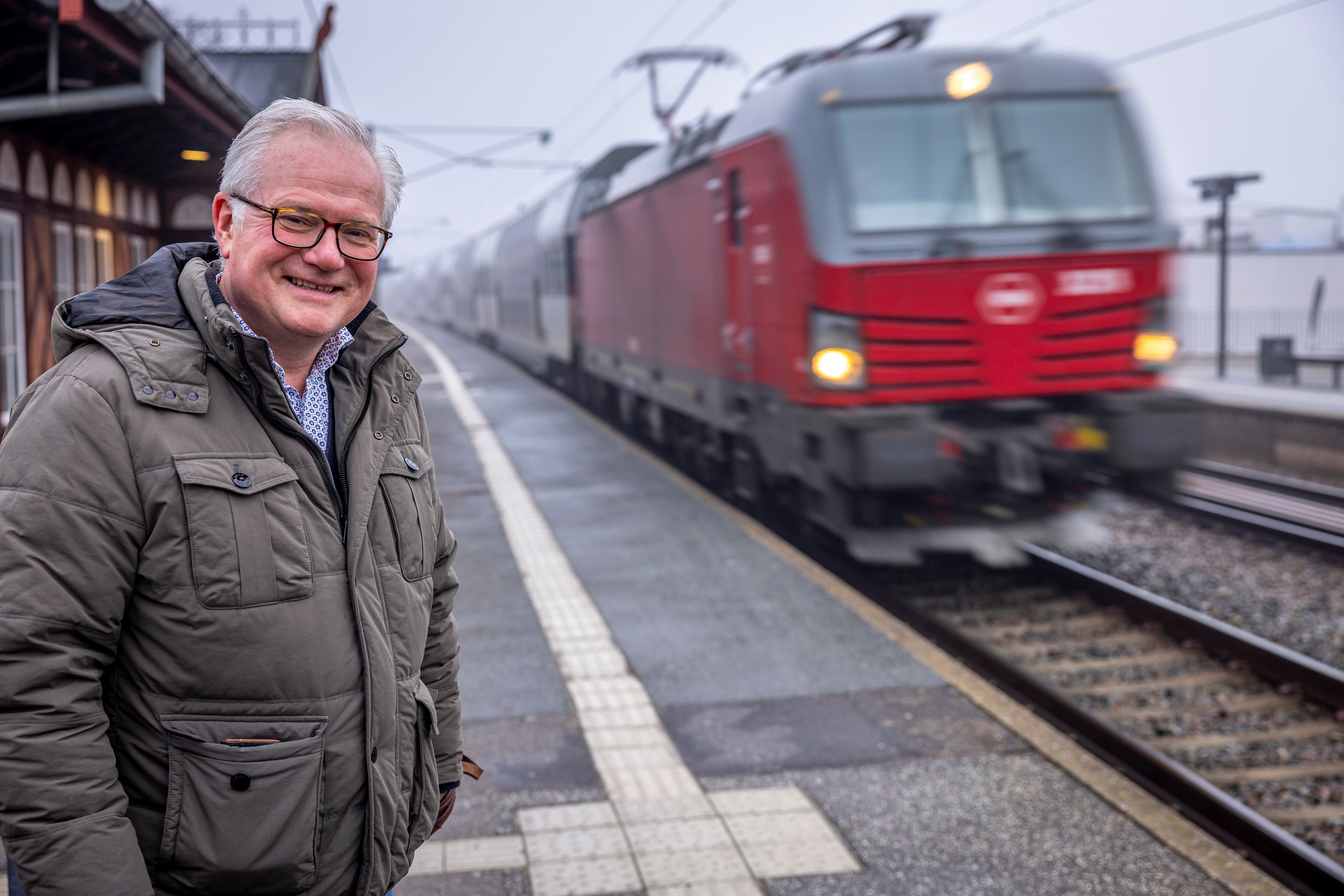 Viceborgmester i Rudersdal Jens Kloppenborg (V), der er formand for visionsudvalget for Vedbæk, smiler stort på Vedbæk Station, der fra december i år får dobbelt så mange afgange. Foto: Lars Sandager Ramlow