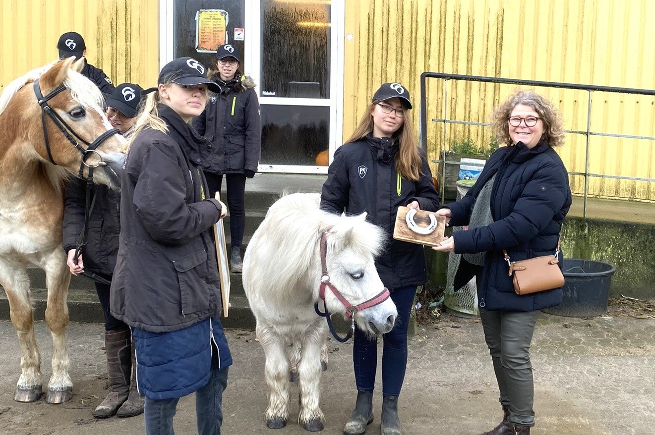 Sekretariatsleder Ghita Zangger Madsen fra Hestens Værn sammen med pigerne fra Next Step Roskilde. Foto: Hestens Værn