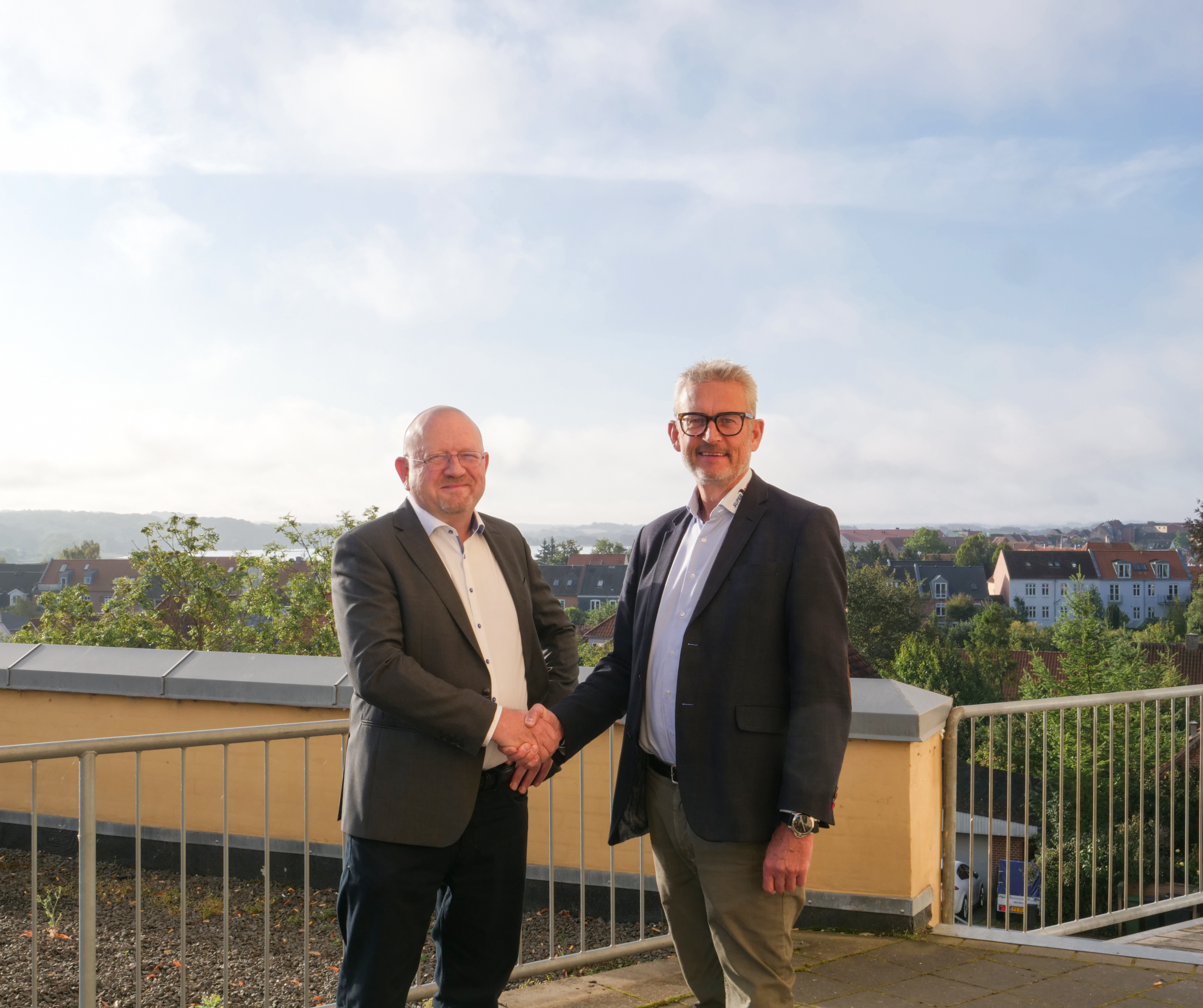 Thomas Harbo, administrerende direktør hos Euromaster Danmark og John Hornbech Christensen, direktør i Super Dæk Service, giver hånd på handlen. Foto: Pressefoto