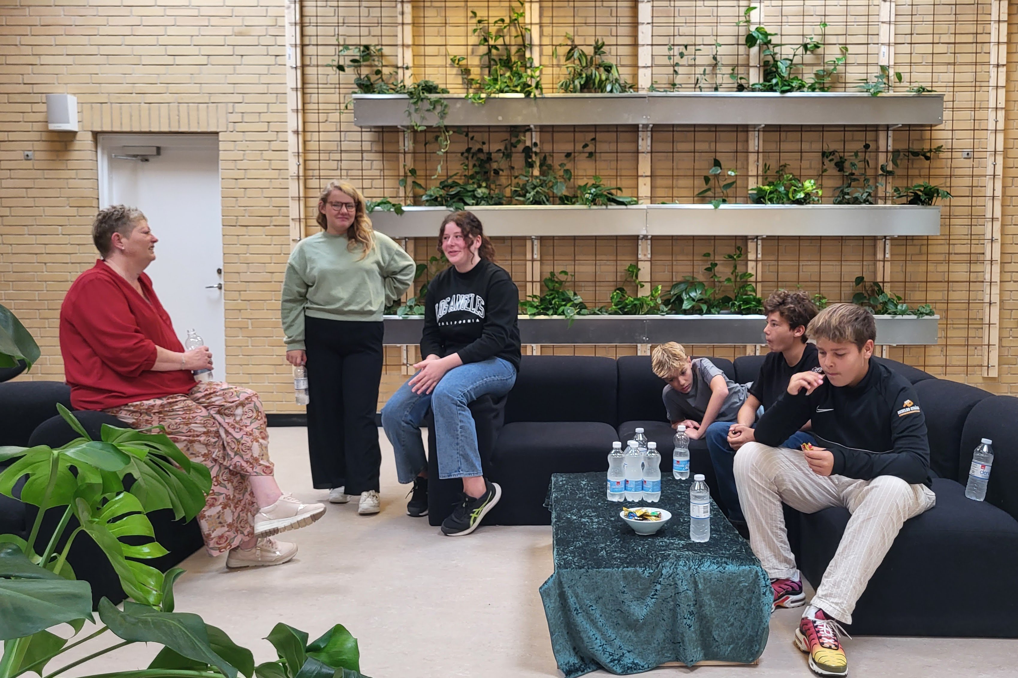 Lærer Lise Cremer og nogle af eleverne, har været med til at idéudvikle biblioteket. Det er også elever, der har været med til at bygge plantevæggen. Foto: Pipaluk Balslev