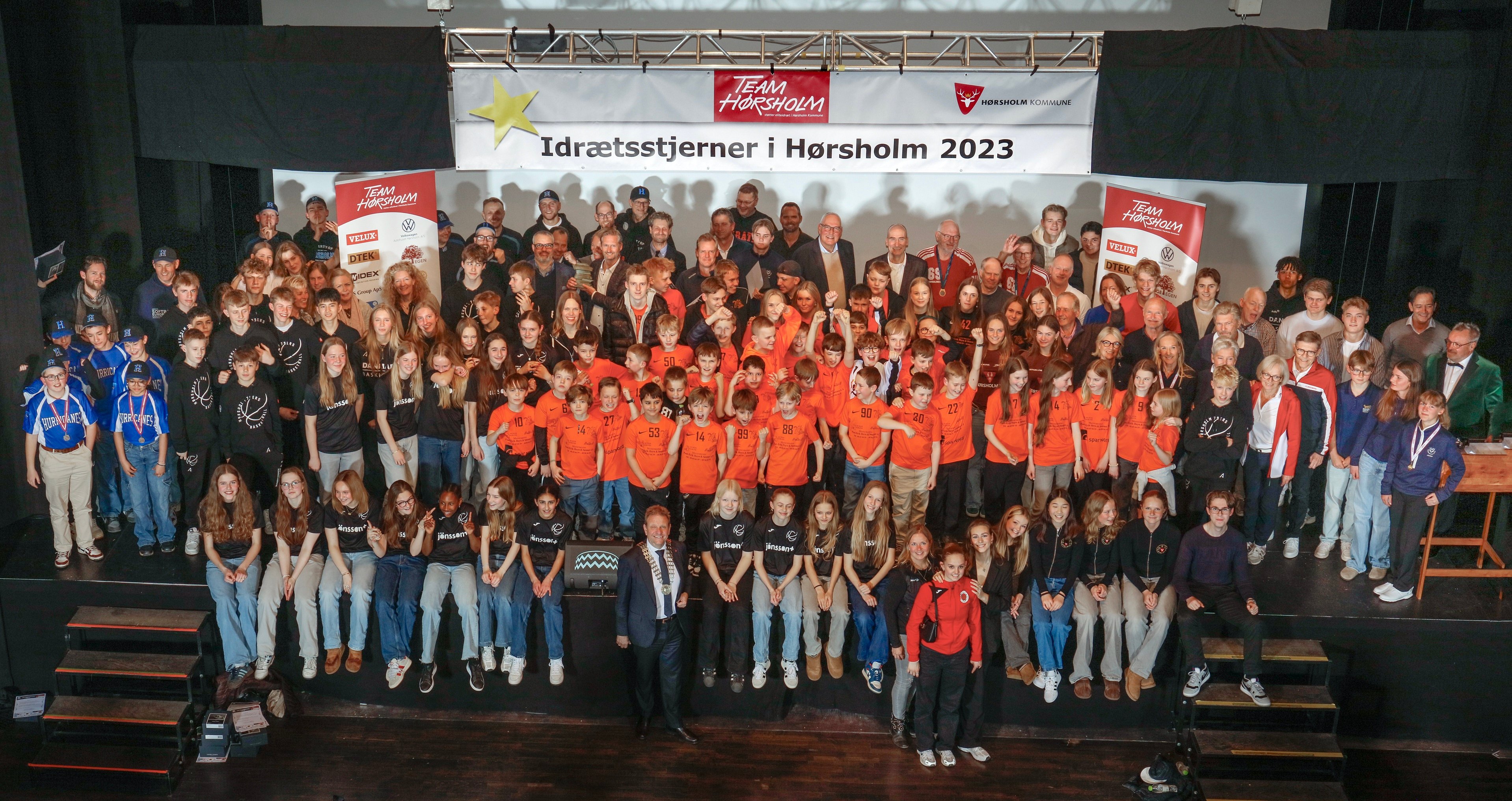Der var fyldt helt op med lokale sportsfolk i Kulturhus Trommen torsdag aften, hvor Team Hørsholm traditionen tro hyldede 347 lokale idrætsudøvere, der i 2023 har udmærket sig med mesterskaber og andre flotte resultater i ind- og udland. Her det faste gruppefoto på scenen. Foto: Henrik Hansen