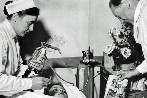 En sygeplejerske betjener håndventilationsudstyret hos en dreng med polio under epidemien, som man kan høre mere om ved foredraget 19. januar. Pressefoto