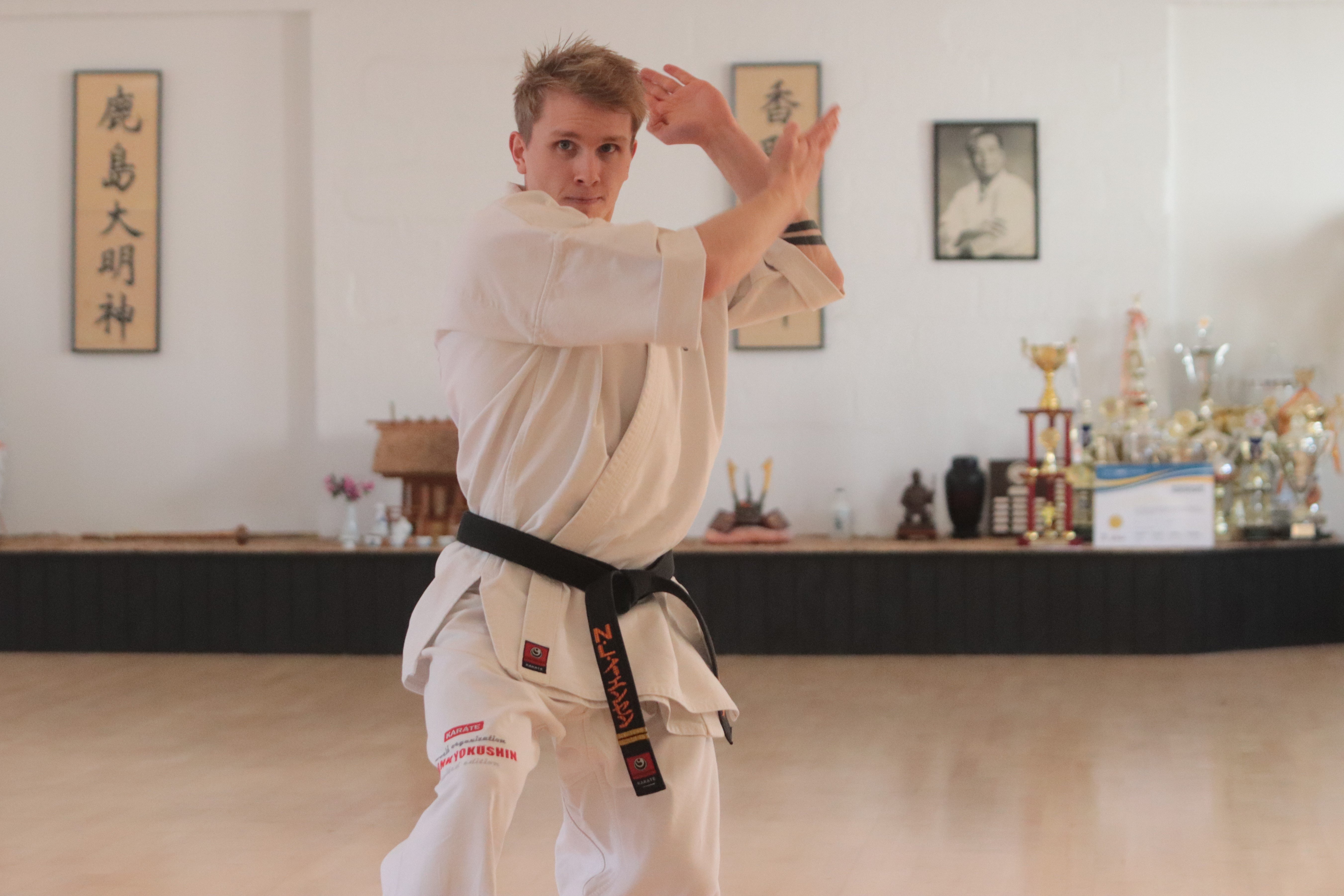 Nikolaj Lunn Jensen i kata-øvelser på klubgulvet i Roskilde. EM-pokalen er monstrummet, der står under billedet af kyokushin-karatens grundlægger Mas Oyama.  Foto: Jeppe Lodberg