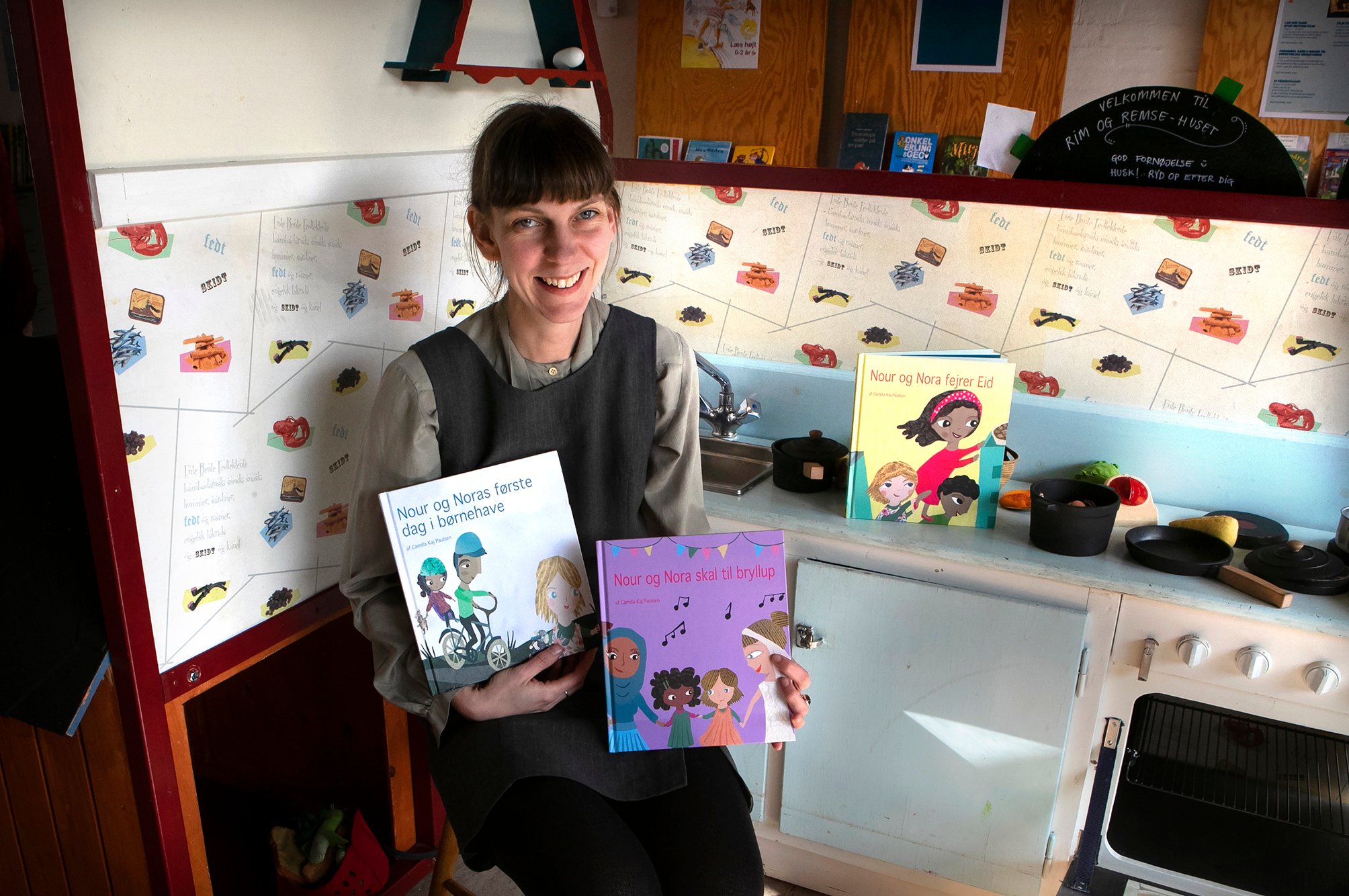 Camilla Kaj Paulsen med tre af bøgerne i sin serie om vennerne Nour og Nora.
