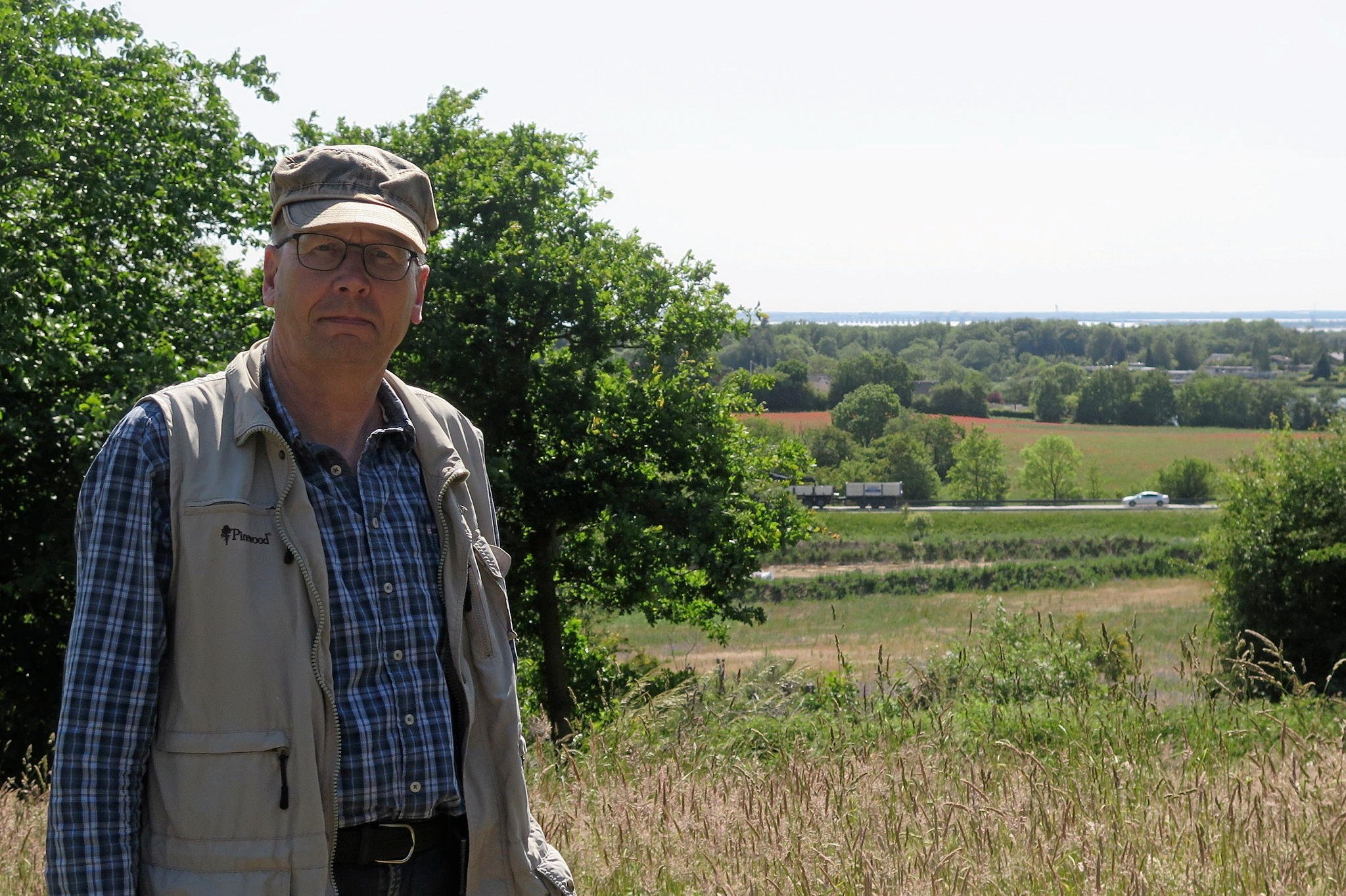 Bo Kayser fra Danmarks Naturfredningsforening glæder sig over udsigterne til et endnu større naturområde. Her ses han på toppen af Munks Banke. Midt i bilen ses Mønsvej, og det er marken ud mod Mønsvej, som man nu vil forsøge at lave mere natur på. Foto: Lars Christensen