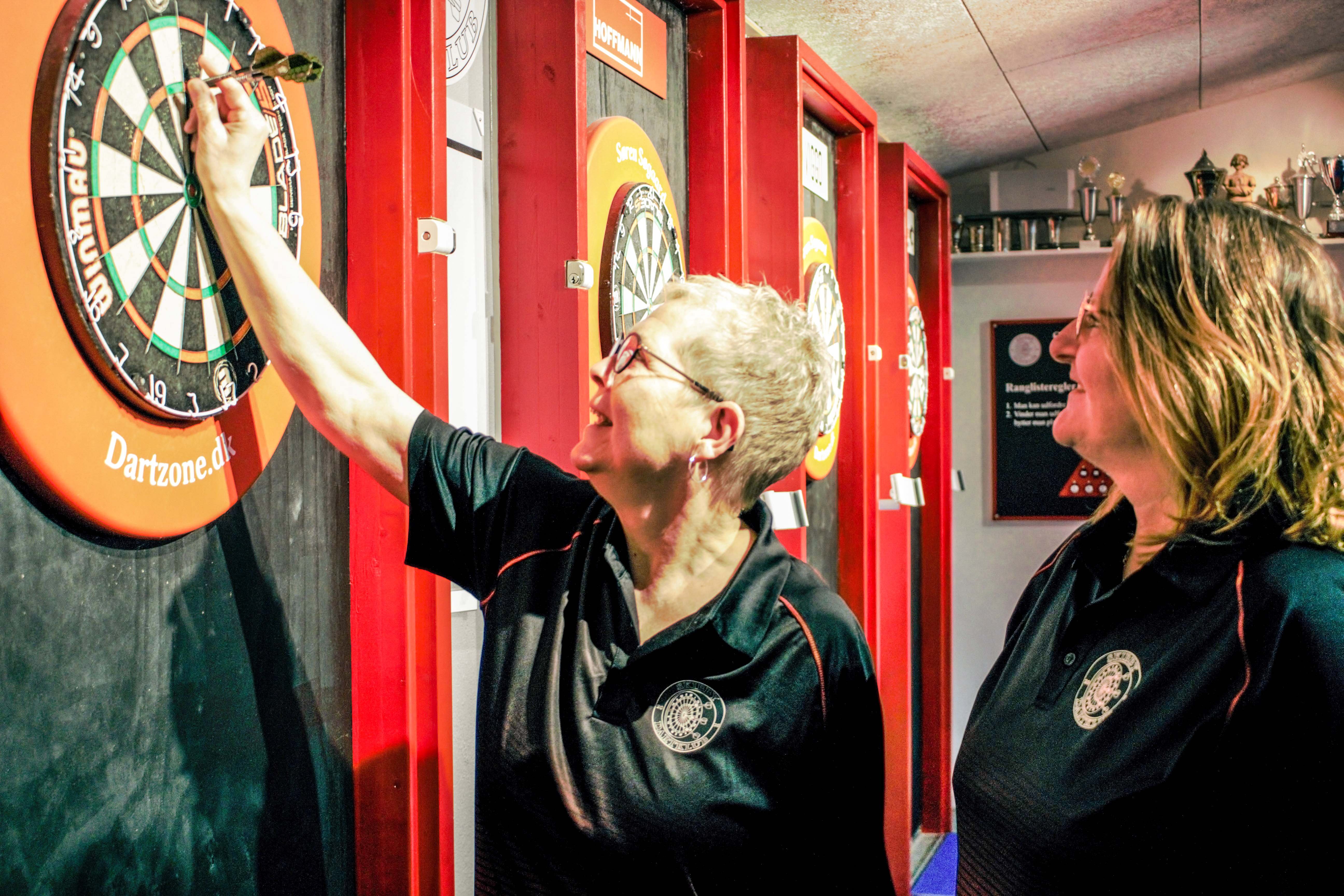 Linda Lykke Olsen (til højre) har travlt forud for afholdelsen af Sjællandsmesterskaberne i Skibby Dart Klub.