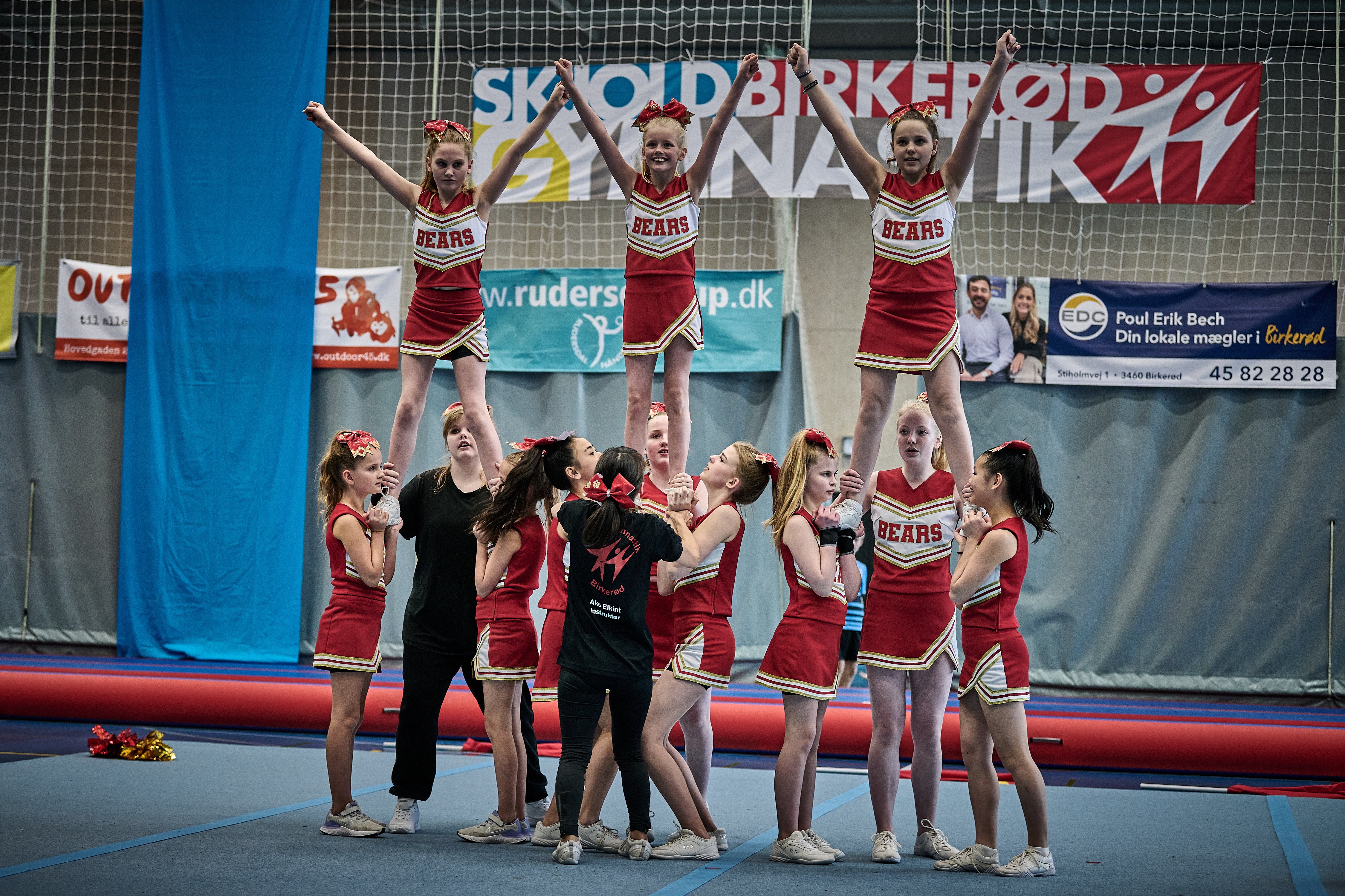 SGB Bears Cheerleading viste styrke og balance i Birkerød Idrætscenter med Skjold Birkerød Gymnastiks fine banner i baggrunden.  Foto: Chris Gosling