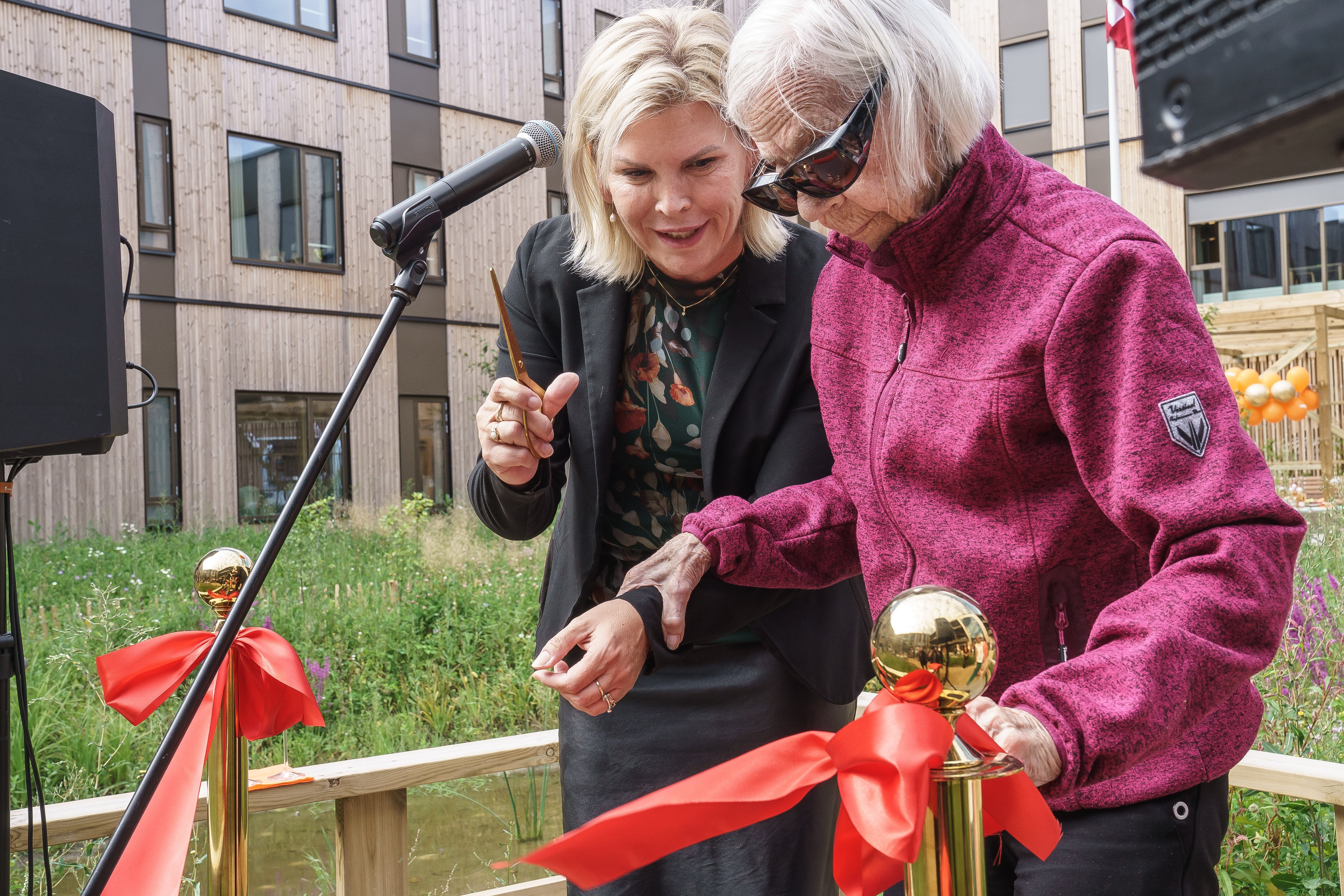 Grethe Pedersen flyttede som den første beboer ind på Fribo Greve den 1. juni. Her klipper hun snoren sammen med borgmester Pernille Beckmann.