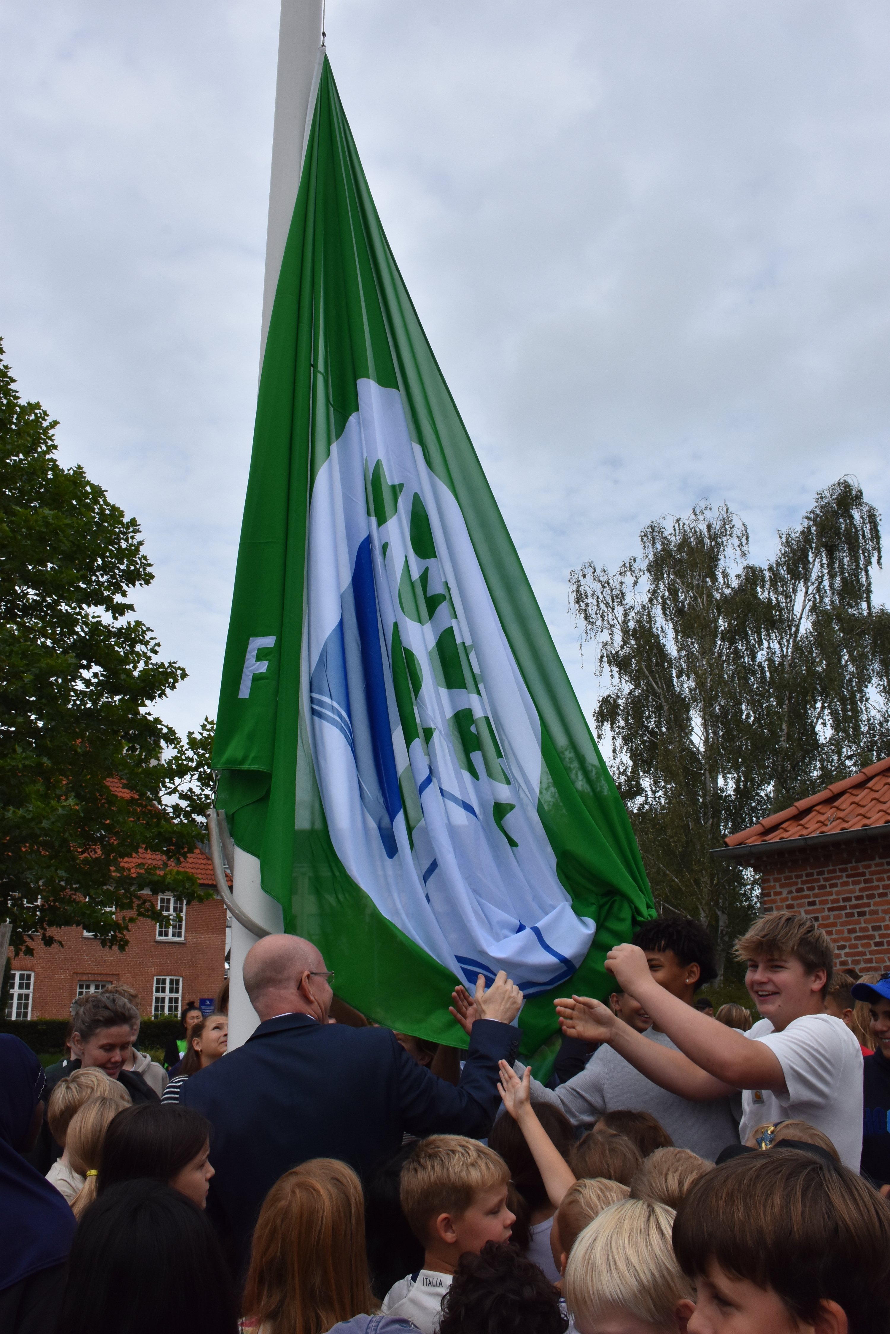 Borgmester Michael Fenger og Tjørnegårdsskolen elever fik i samarbejde hejst det grønne flag, der signalerer, at skolen har stort fokus på bæredygtighed. Foto: Gentofte Kommune