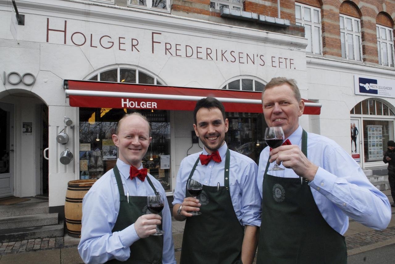 Tiden har stået stille i købmandsbutikken på Ordrupvej. Heldigvis. Sund fornuft siger, at 'Holger' for længst burde være knægtet af de store supermarkeder, men vin- og delikatesseforretningen har overlevet, fordi kunderne sætter pris på sortimentet, duften, servicen og folkene bag disken