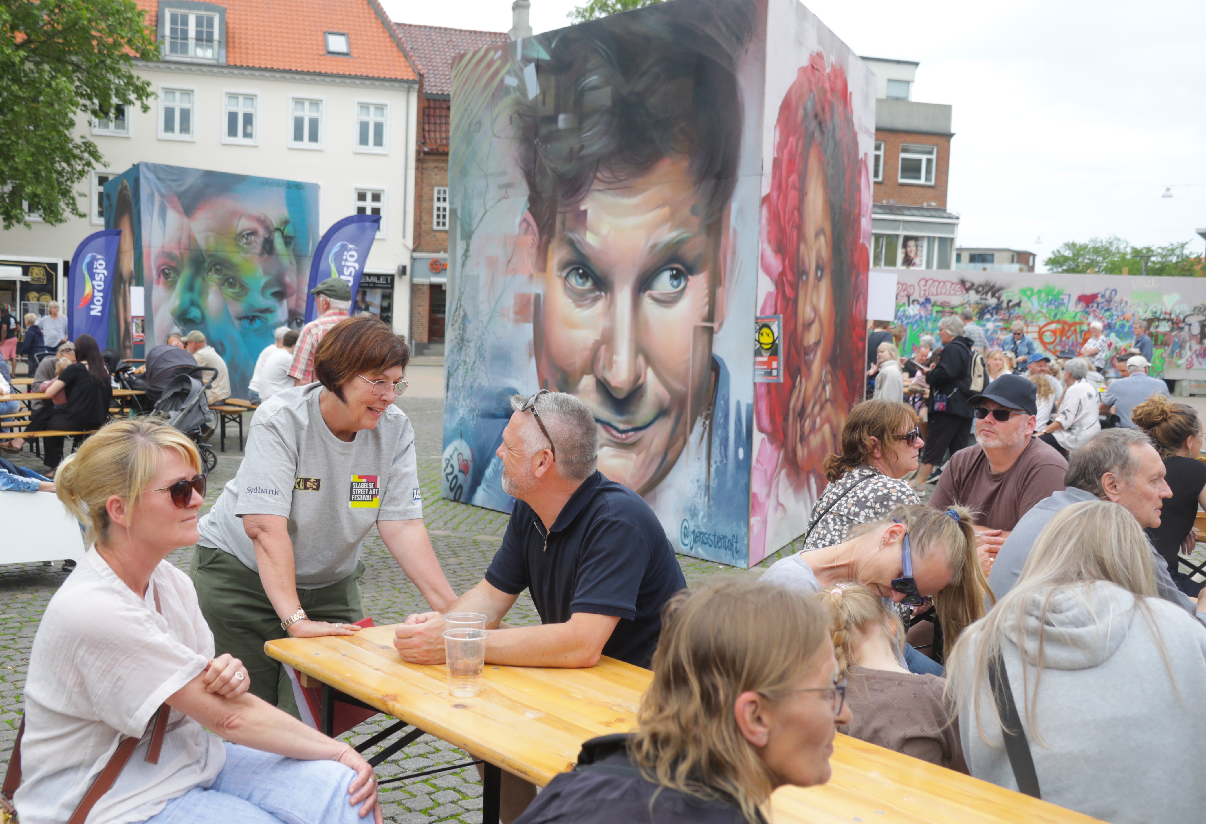 - En god fest, med mange besøgende, siger Helle Madsen (stående) om årets street art festival i bymidten. Foto: Evan - En god fest, med mange besøgende, siger Helle Madsen (stående) om årets street art festival i bymidten. Foto: Evan