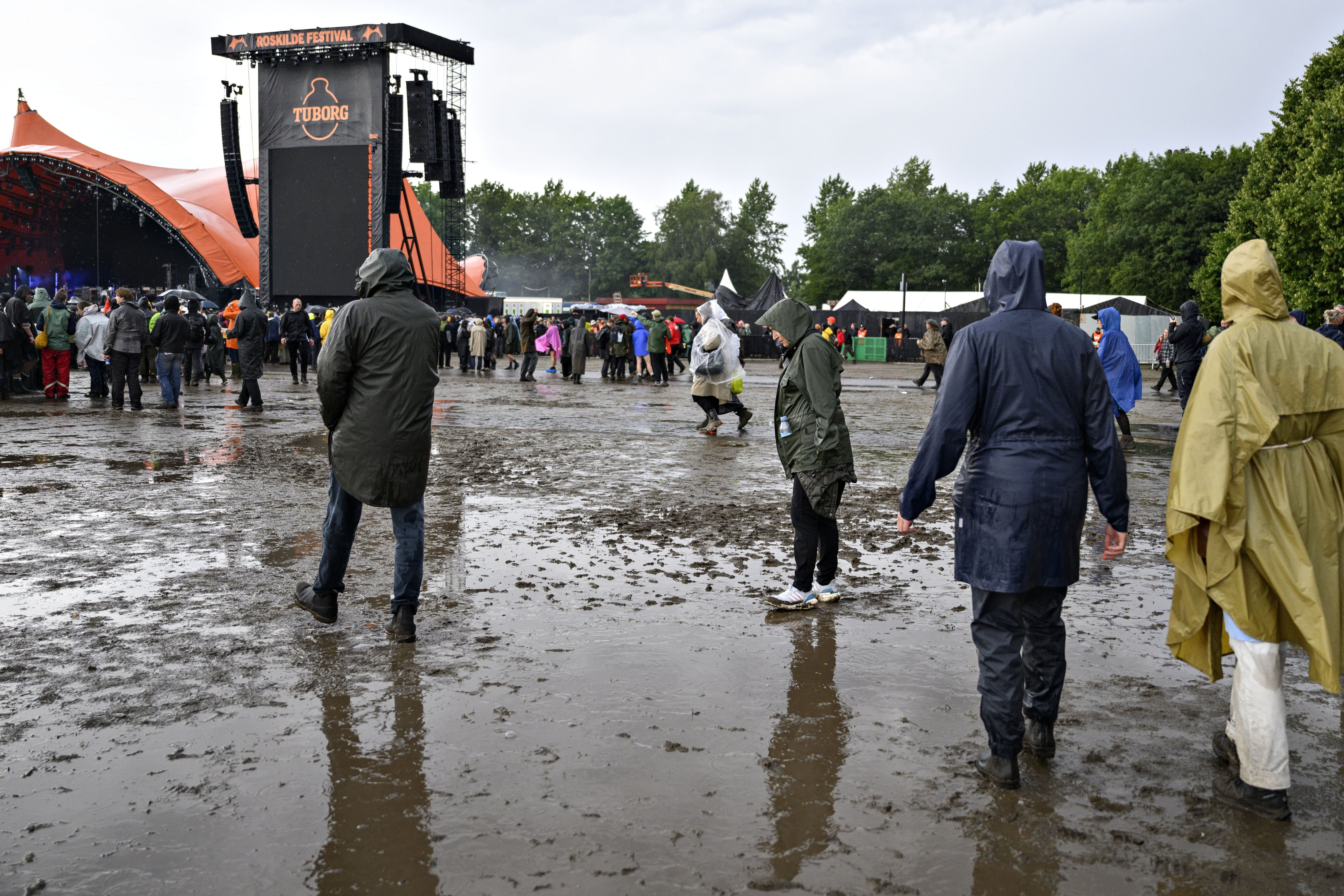Festivalgæster på festivalpladsen foran Orange scene efter regnen lørdag aften under Roskilde Festival den 6. juli 2024.