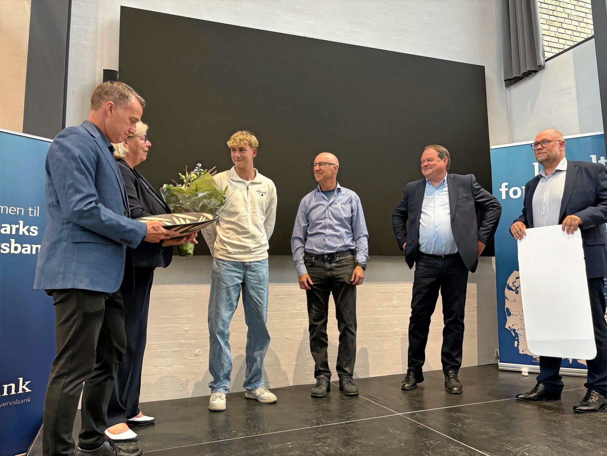 Borgemester Carsten Rasmussen er klar til at overrække fadet, Næstved Erhvervsforenings forperson Helle Andresen står klar med blomsterne og Sydbanks områdedirektør Kasper Bæk med checken.
