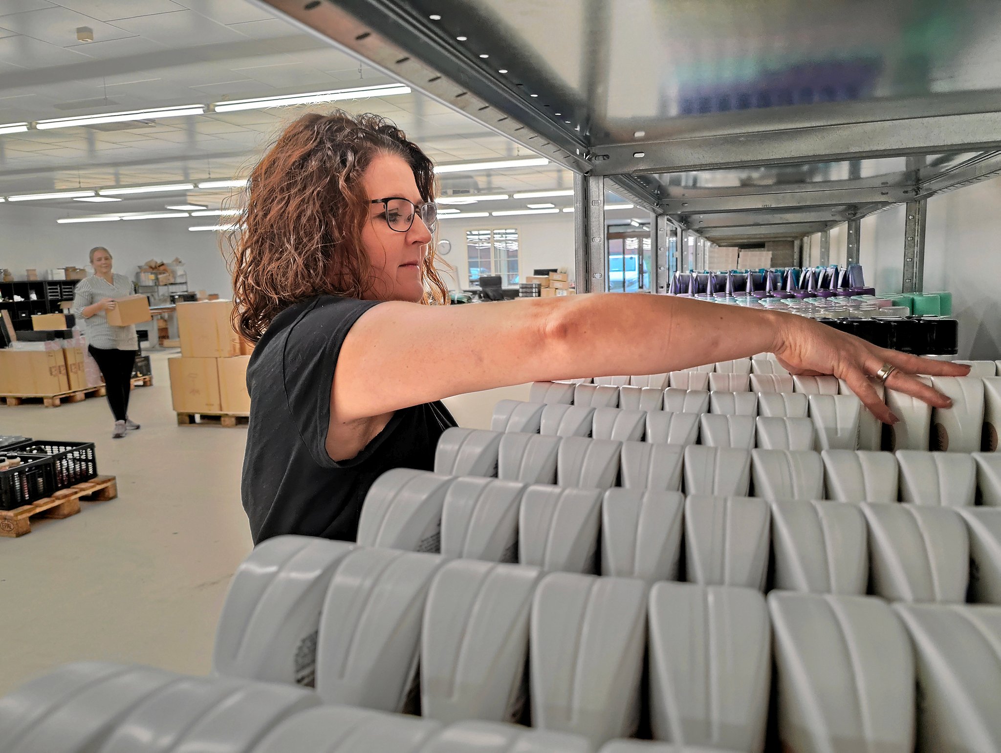 Camilla Spottog er bedst kendt som Mille. Hun driver Impocurl og er i fuld gang med at få styr på Olaplex-produkterne. I baggrunden ses Helle Wiesel.