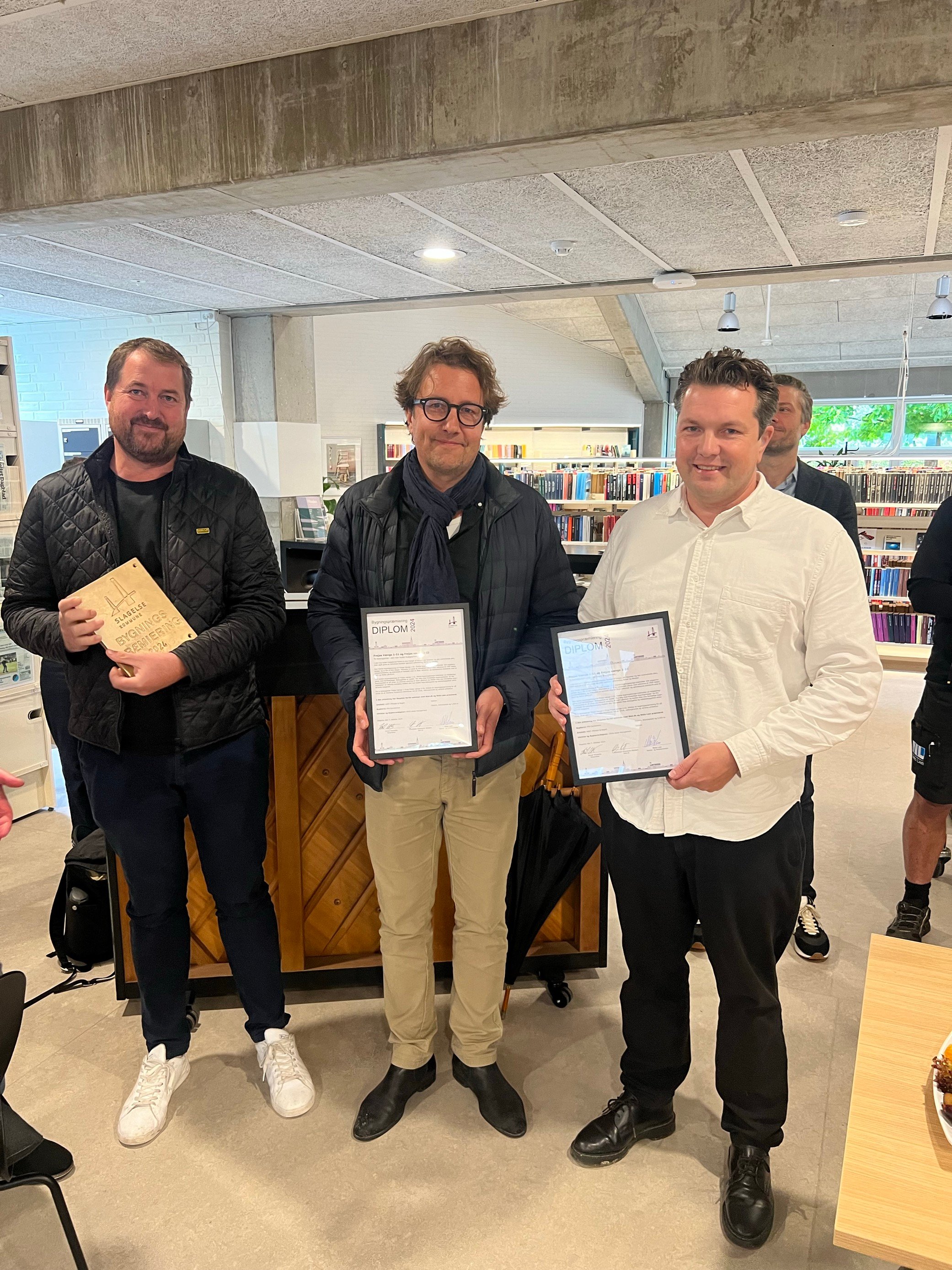 Fra venstre mod højre ses Jakob Andersen, Søren Stoustrup og Kalle Jørgensen fra AART, der var en af to vindere ved Årets Bygningspræmiering, der mandag eftermiddag blev uddelt på Slagelse Bibliotek.