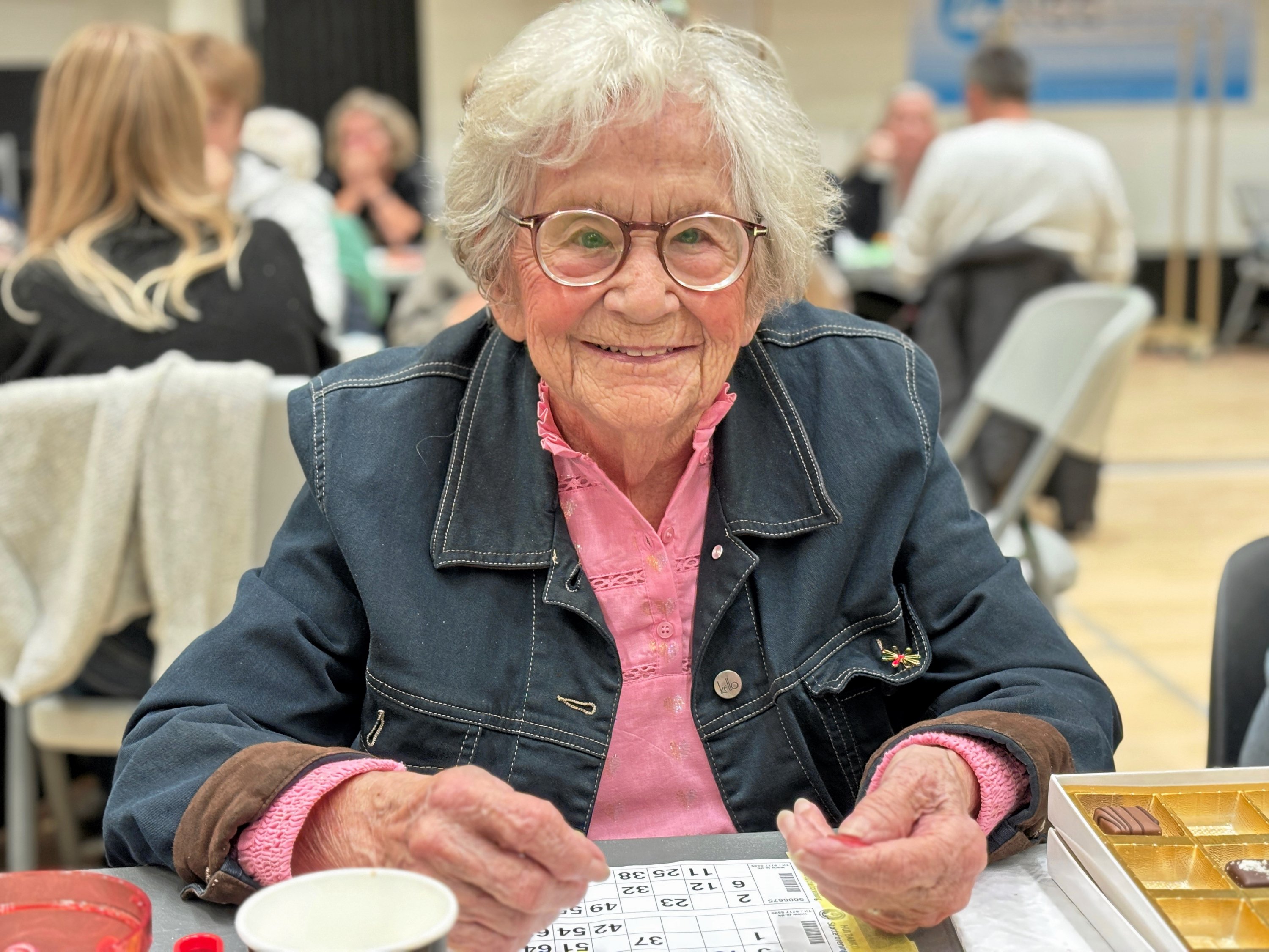 Smilende Ella Nielsen fra Hørsholm har her lige rundet 100 år og sidder klar til endnu et banko-slag i Hørsholmhallen.