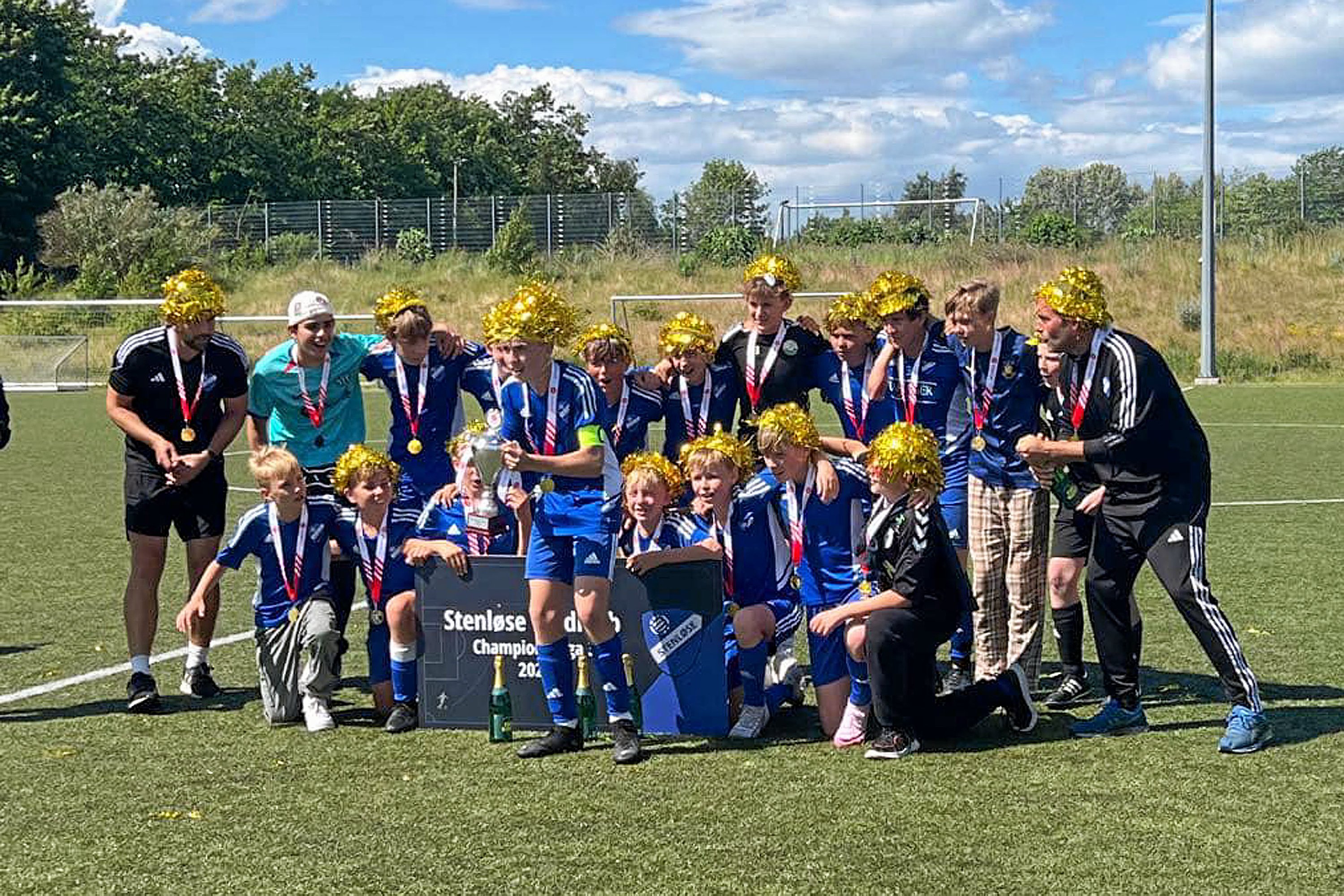 Guld-parykker og pokal-løft. U14-drengene i Stenløse Boldklub fejrer deres store triumf.