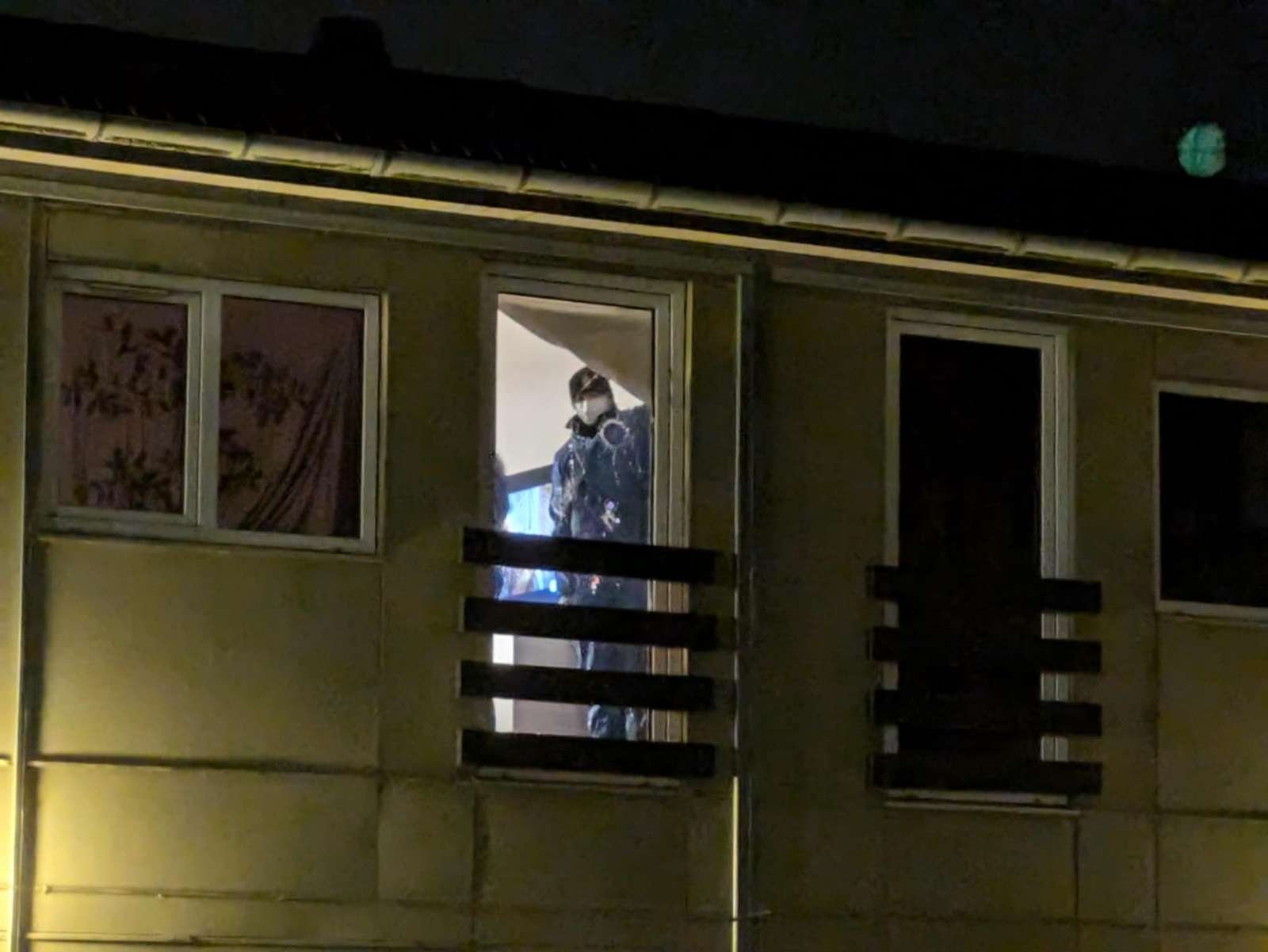 En politimand undersøger ruden i en lejlighed, hvor der blev skudt imod i begyndelsen af november.