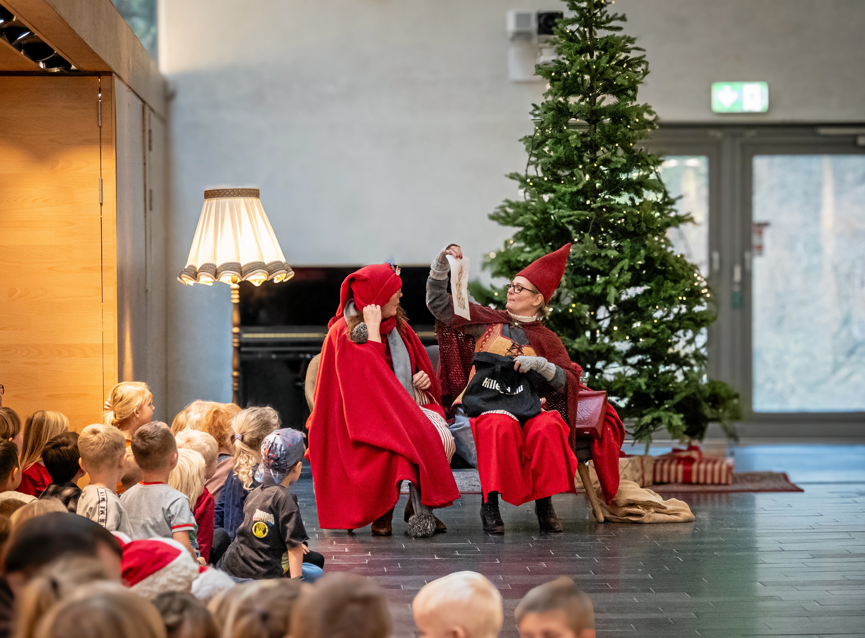 Nisserne satte sig foran bibliotekets store juletræ med børnene i rundkreds rundt omkring sig. - Hillerød.nu/Ann Jørgensen Nisserne satte sig foran bibliotekets store juletræ med børnene i rundkreds rundt omkring sig.