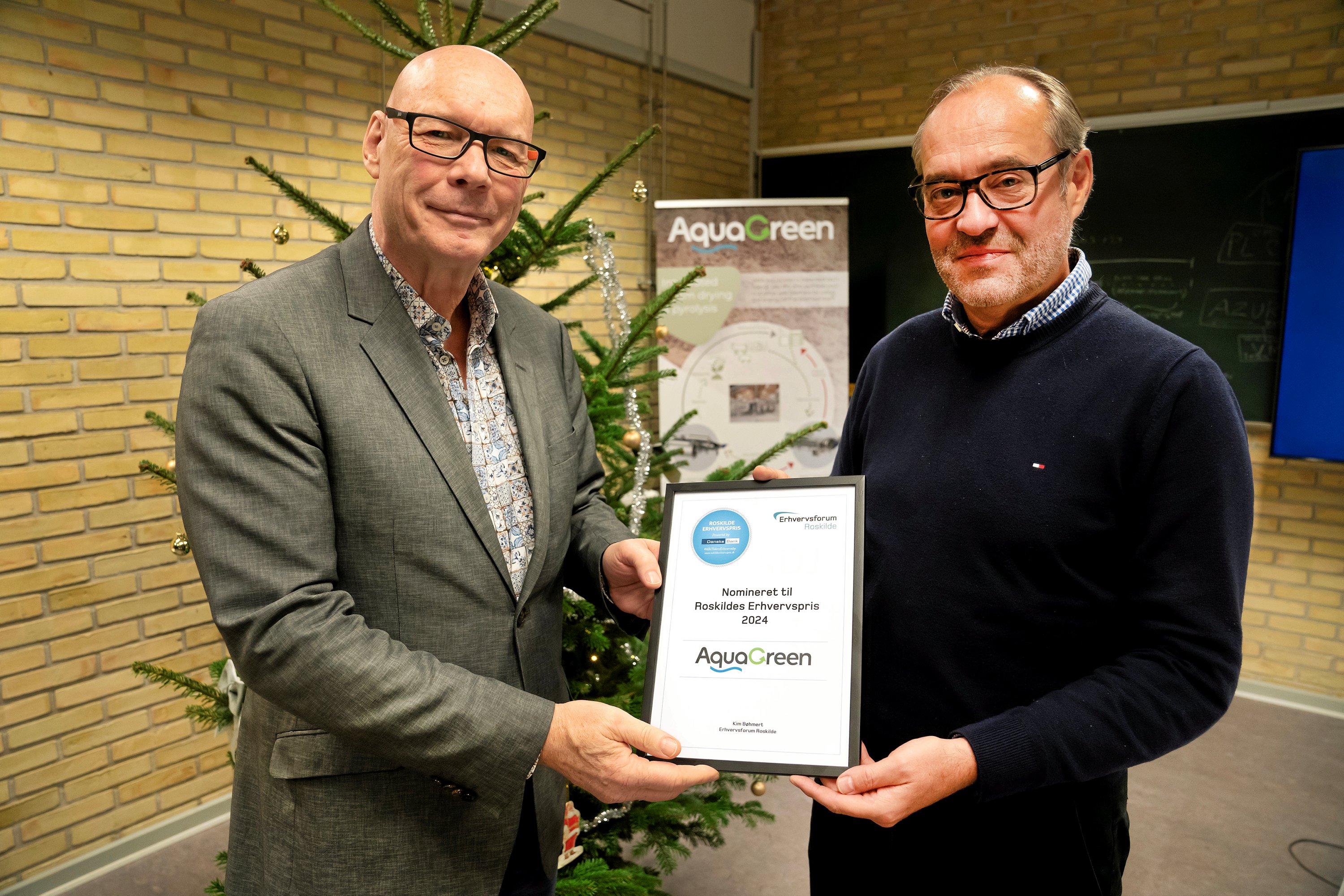 Aquagreen er årets sidste nominerede til Roskilde Erhvervspris. Erhvervs- og projektkonsulent i Erhvervsforum, Kim Bøhmert giver her administrerende direktør hos Aquagreen, Henning Schmidt-Pedersen diplomet.