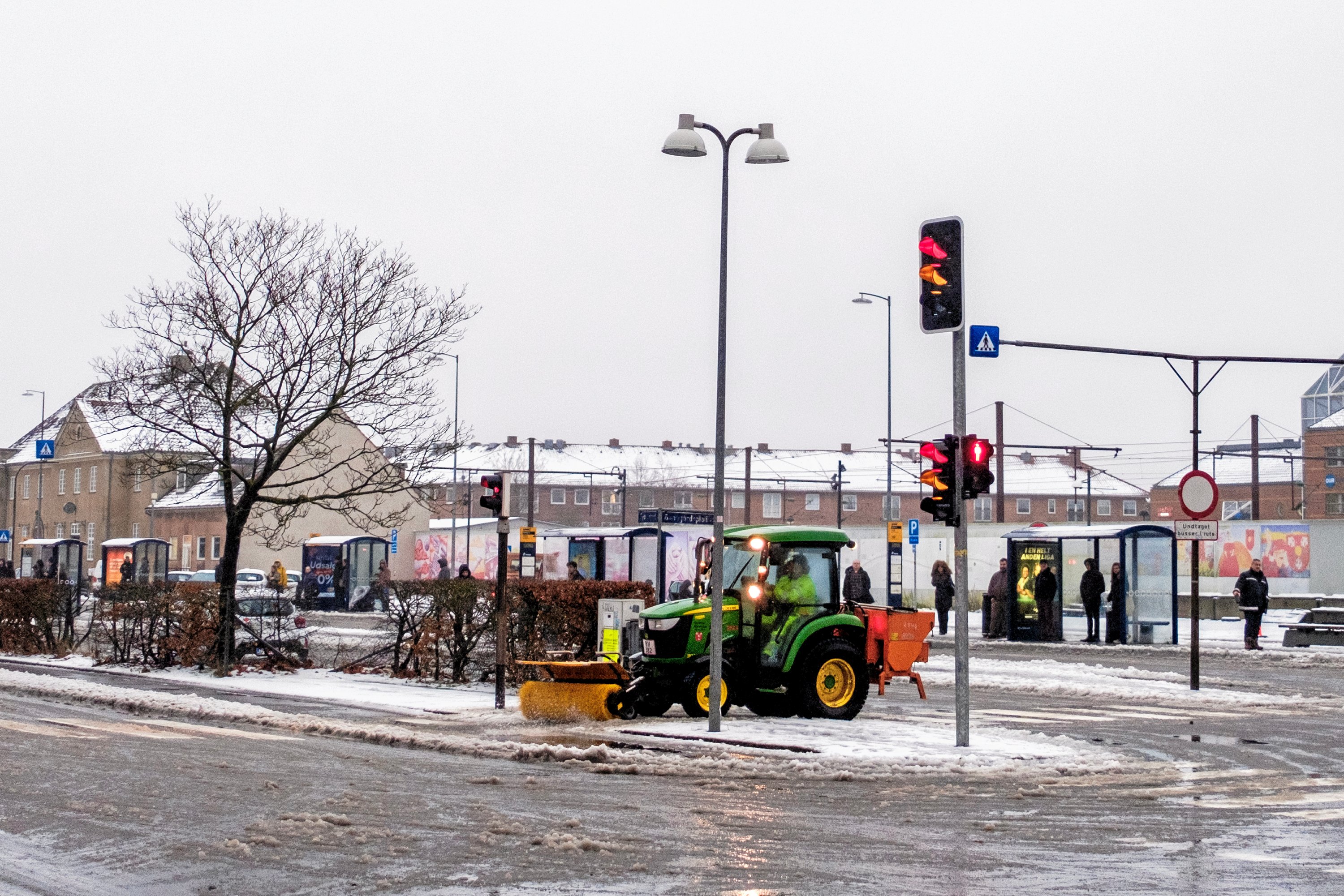 Her bliver der ryddet sne på stationsforpladsen.