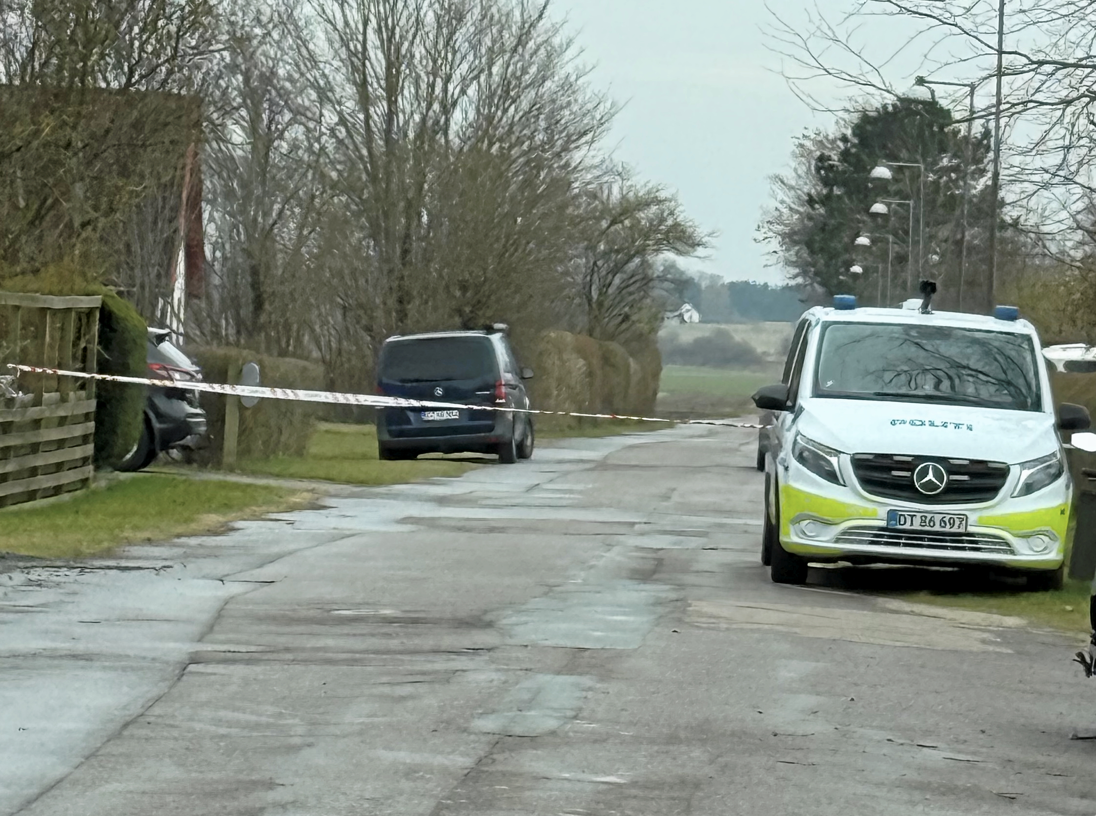 Politiet afspærrede vejen mens de undersøgte gerningsstedet, hvor en 45-årig kvinde blev overfaldet og knivdræbt i sit hjem. En 55-årig mand blev anholdt kort tid efter.