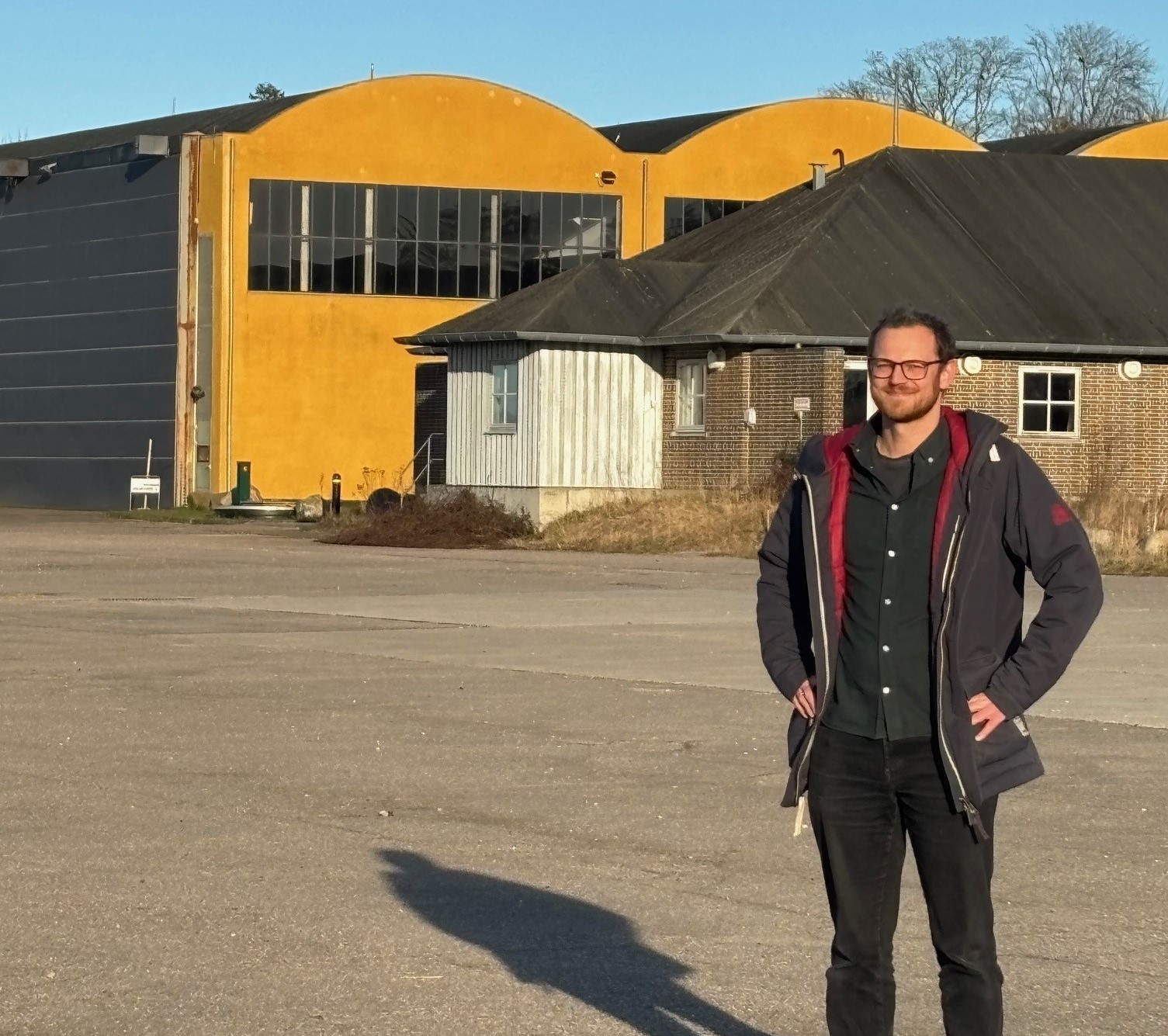 Peter Ravnskjær Kroer på den asfalterede tidligere flyveplads bag Hangar 3, hvor der er beboerhus. Det er denne plads, som foreningen har fået råderet over, så de kan realisere drømmen om en historisk legeplads.