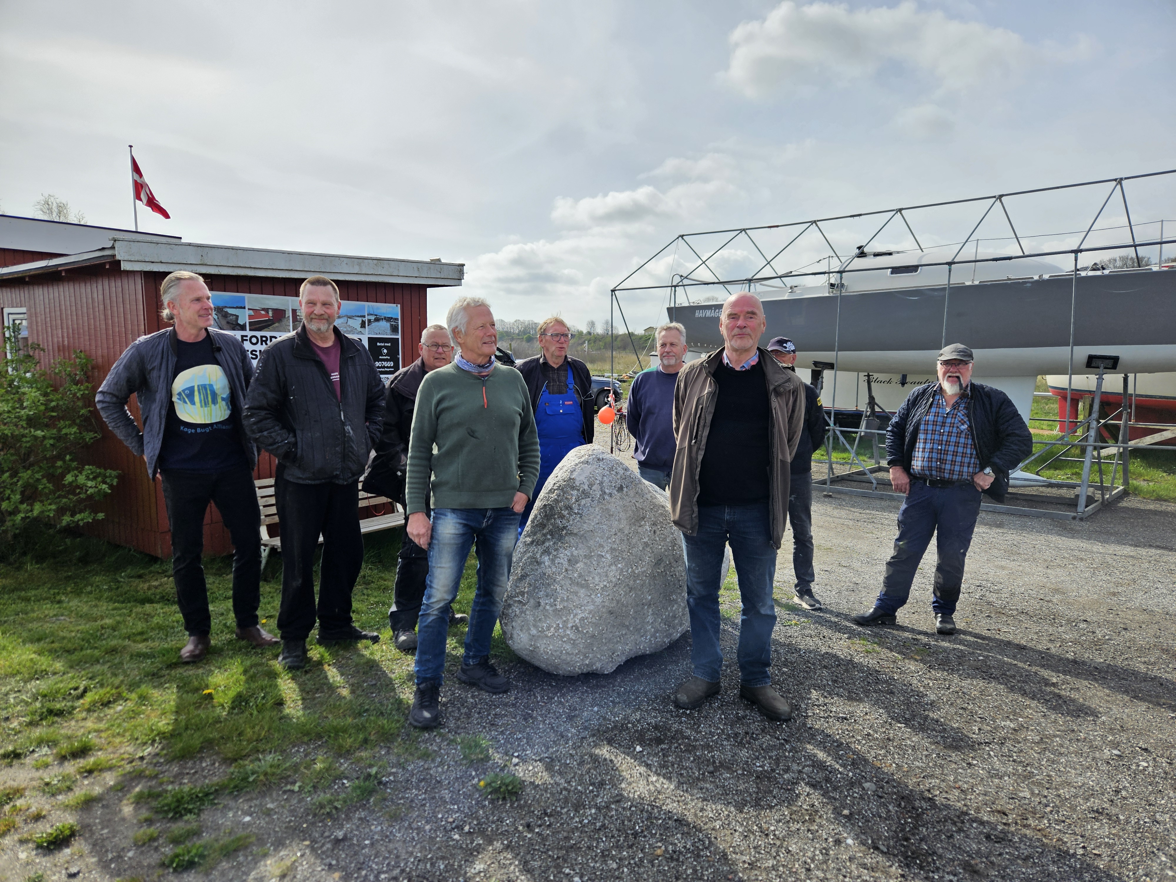 Daværende borgmester Henning Urban Dam (S), bestyrelsesmedlemmer for Foreningen Bøgeskov Havn og Onsdagsgruppen var samlet for at fejre, at Bøgeskov Havn er ved at ligne sig selv igen i april 2025. Formand Lars Honoré ses forrest til højre. .
