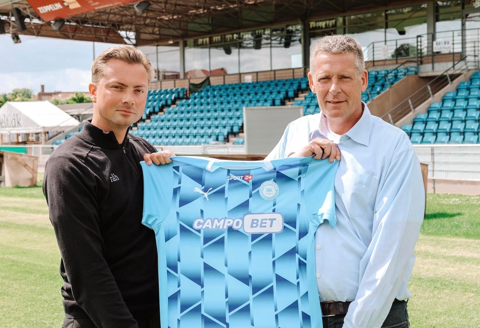 FC Roskildes kommercielle chef Patrick Werther og Ole Hetman, skandinavisk direktør i Soft2Bet, med den nye hjemmebanetrøje. - FC Roskilde FC Roskildes kommercielle chef Patrick Werther og Ole Hetman, skandinavisk direktør i Soft2Bet, med den nye hjemmebanetrøje.