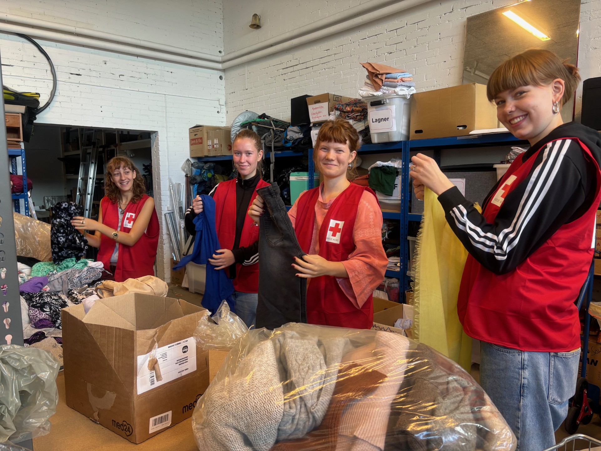 Unge frivillige fra "Amtet" sorterer tøj til Røde Kors-butikken.