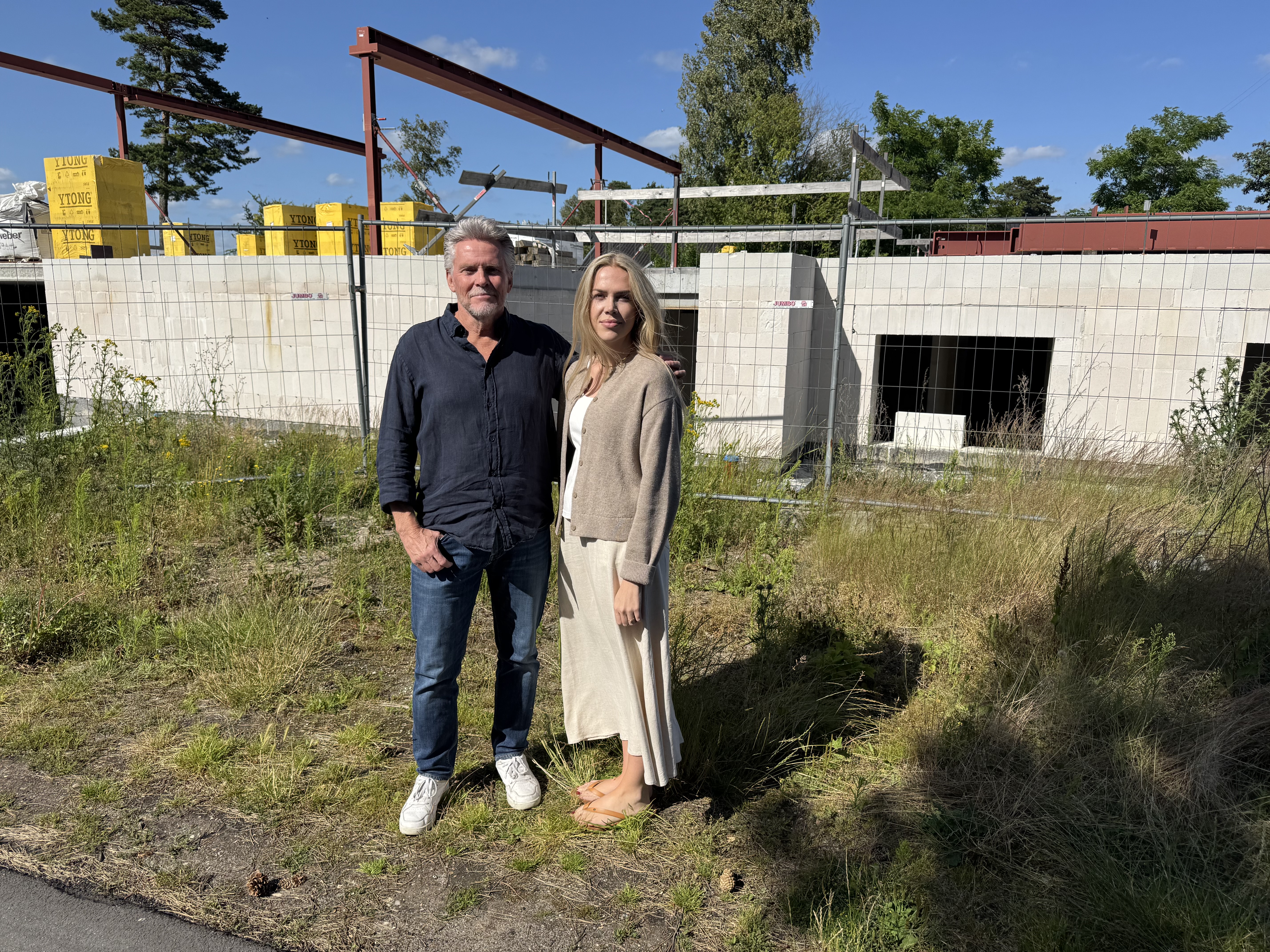 Frank Christoffersen og hans datter Stine Fredsgaard foran det byggeri, som er stoppet. Her skulle de have boet i hvert sit rækkehus, men tæt på hinanden.