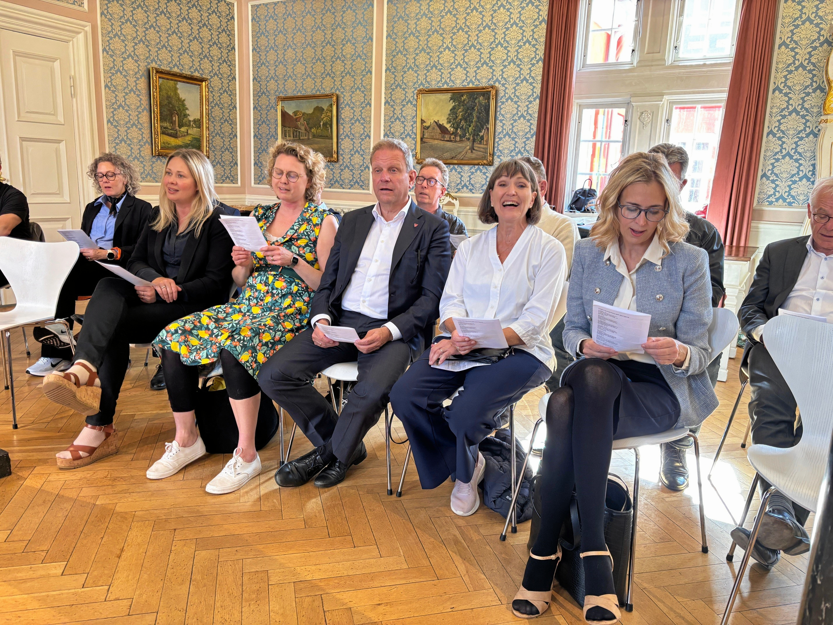 Sophiekoret optrådte, uafhængigt af denne sag, for Hørsholm Kommunalbestyrelse, hvor der var fællessang i den historiske byrådssal på det gamle rådhus. De fem i midten er fra venstre Maj Allin Thorup (K), Louise Zabel (SF), borgmester Morten Slotved (K), Annette Wiencken (K) og Ann Lindhardt (V).